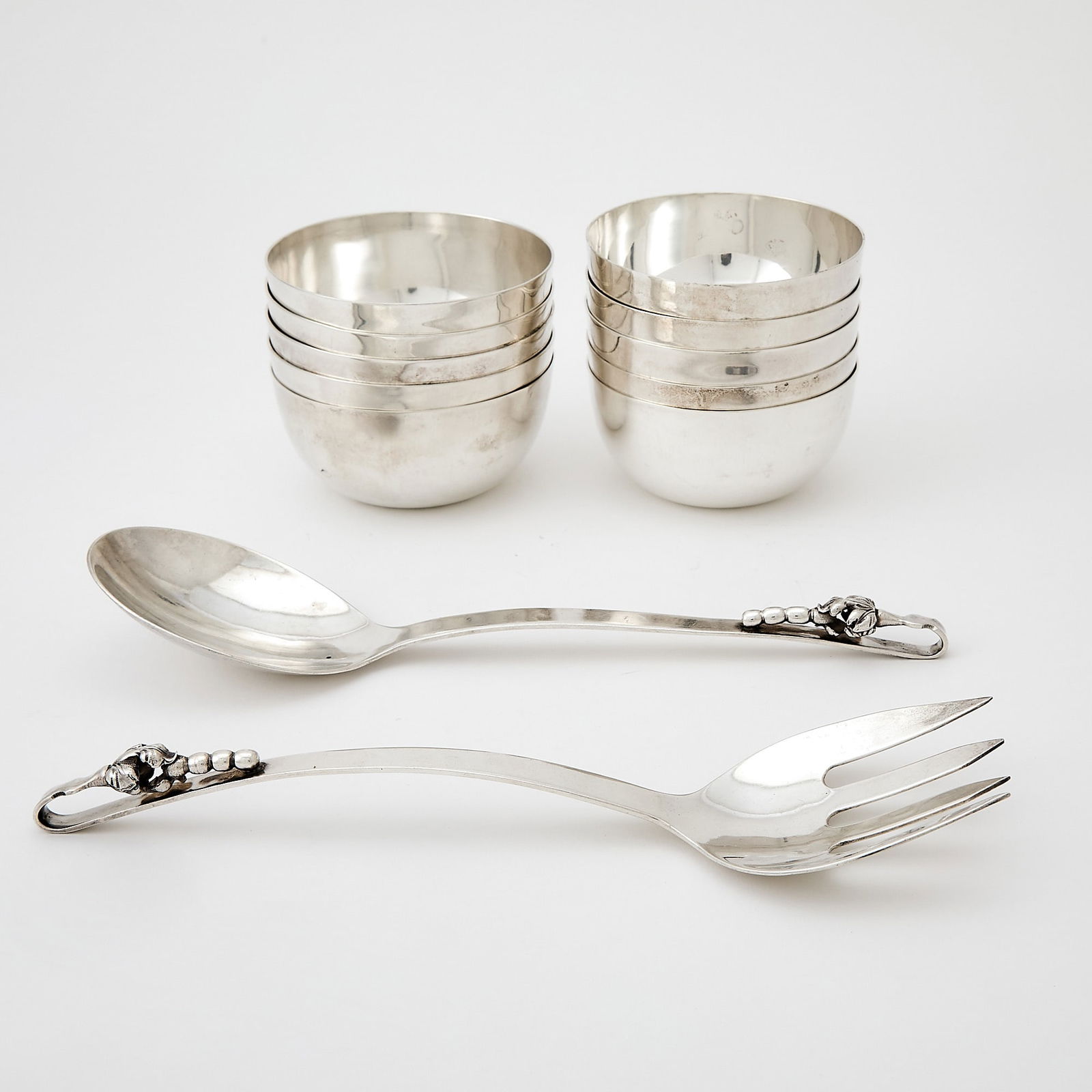 Set of Ten Mexican Sterling Silver Bowls: Tane, mid 20th century Height 2 inches (5 cm), diameter 3 3/4 inches (9.5 cm); Together with a Pair of Mexican Sterling Silver Salad Servers. Total approximately 49 ounces.
