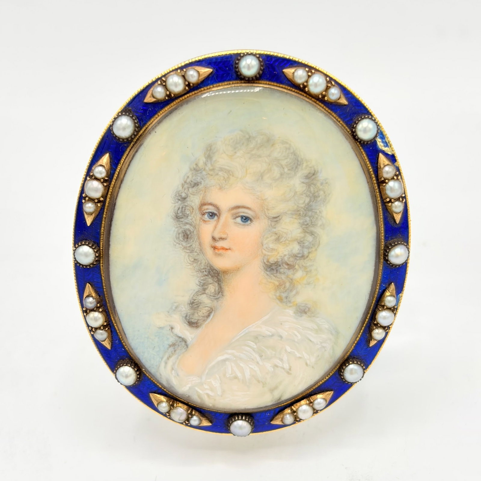 English School: Late 18th Century Portrait Miniature of a Young Woman in White Dress Unsigned Watercolor, in an enamel and seed pearl frame Height 2 3/4 inches. chip to enamel border u.r.