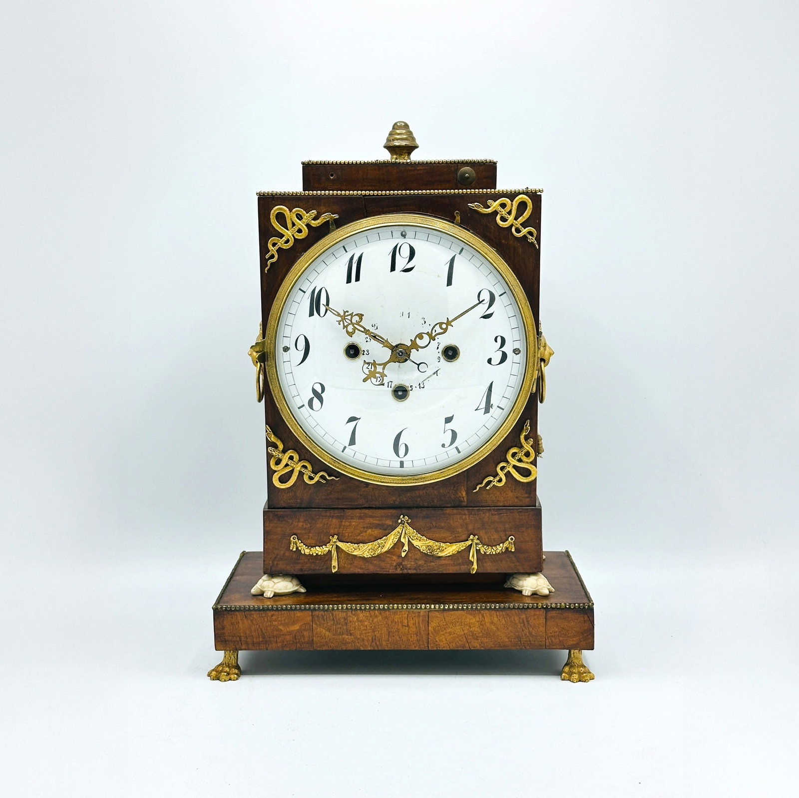 Continental Neoclassic Bronze Mounted Fruitwood Mantel Clock: Possibly Austrian, early 19th century Height 15 1/4 inches, width 10 1/4 inches, depth 6 3/4 inches. Dial worn, some beading loose or missing