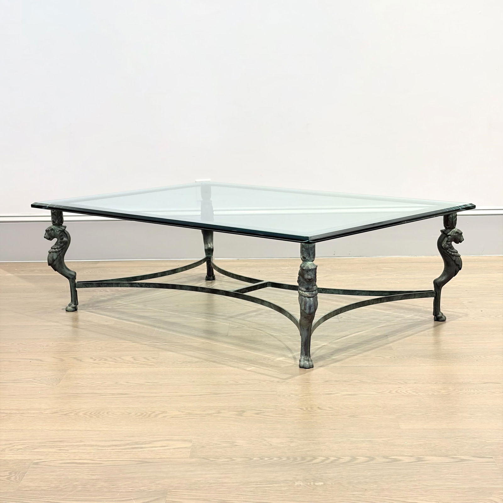 Patinated Bronze and Glass Coffee Table: Mid 20th centuryWith mythical beast-form legs.Height 16 inches, width 35 1/2 inches, depth 35 1/2 inches.