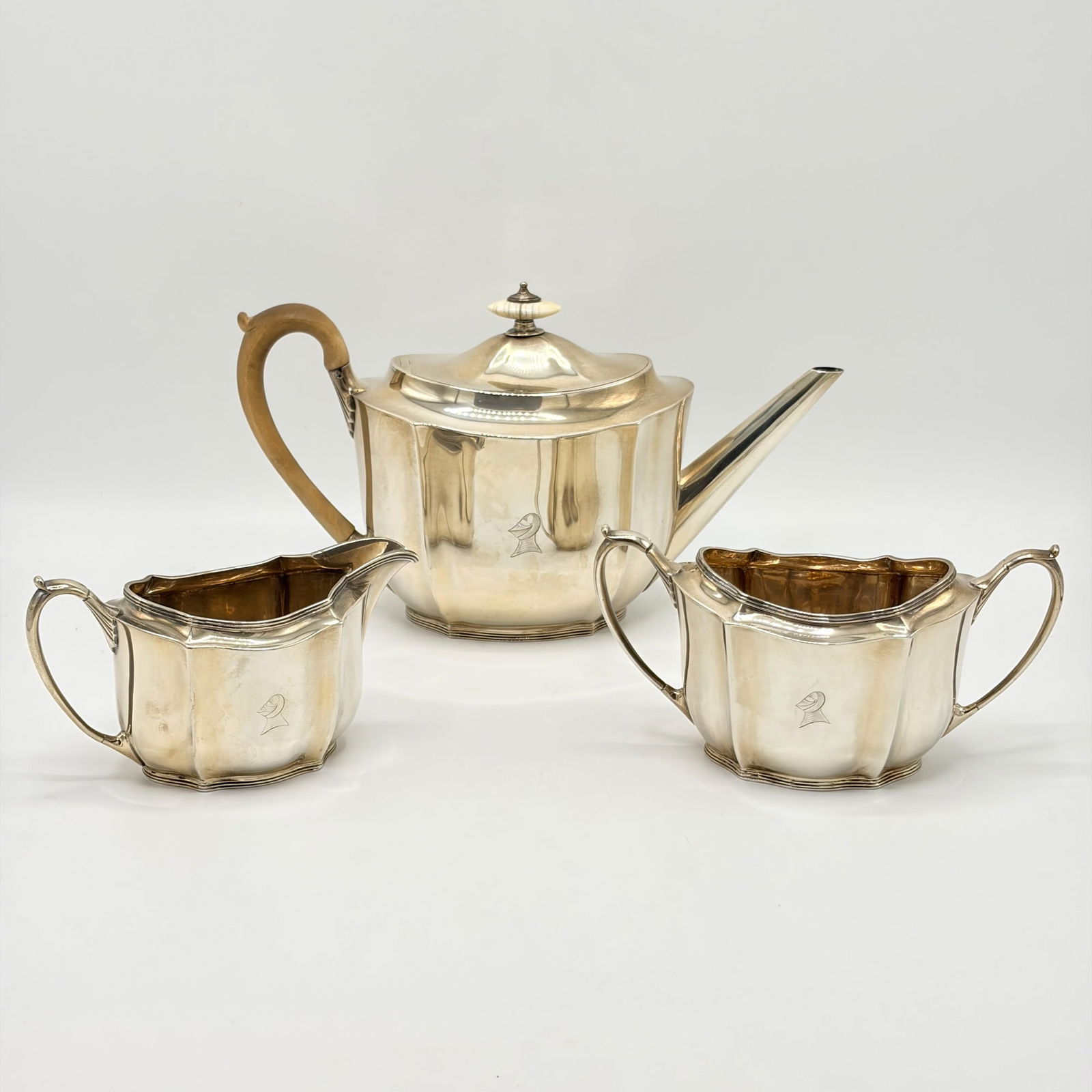 George V Sterling Silver Tea Service: Ernest J Lowe, London, 1926-1928Each shaped oval body engraved with heraldic crest. Height of teapot 6 inches; total approximately 34 ounces, all in; Together with a Reed & Barton Silver Plated