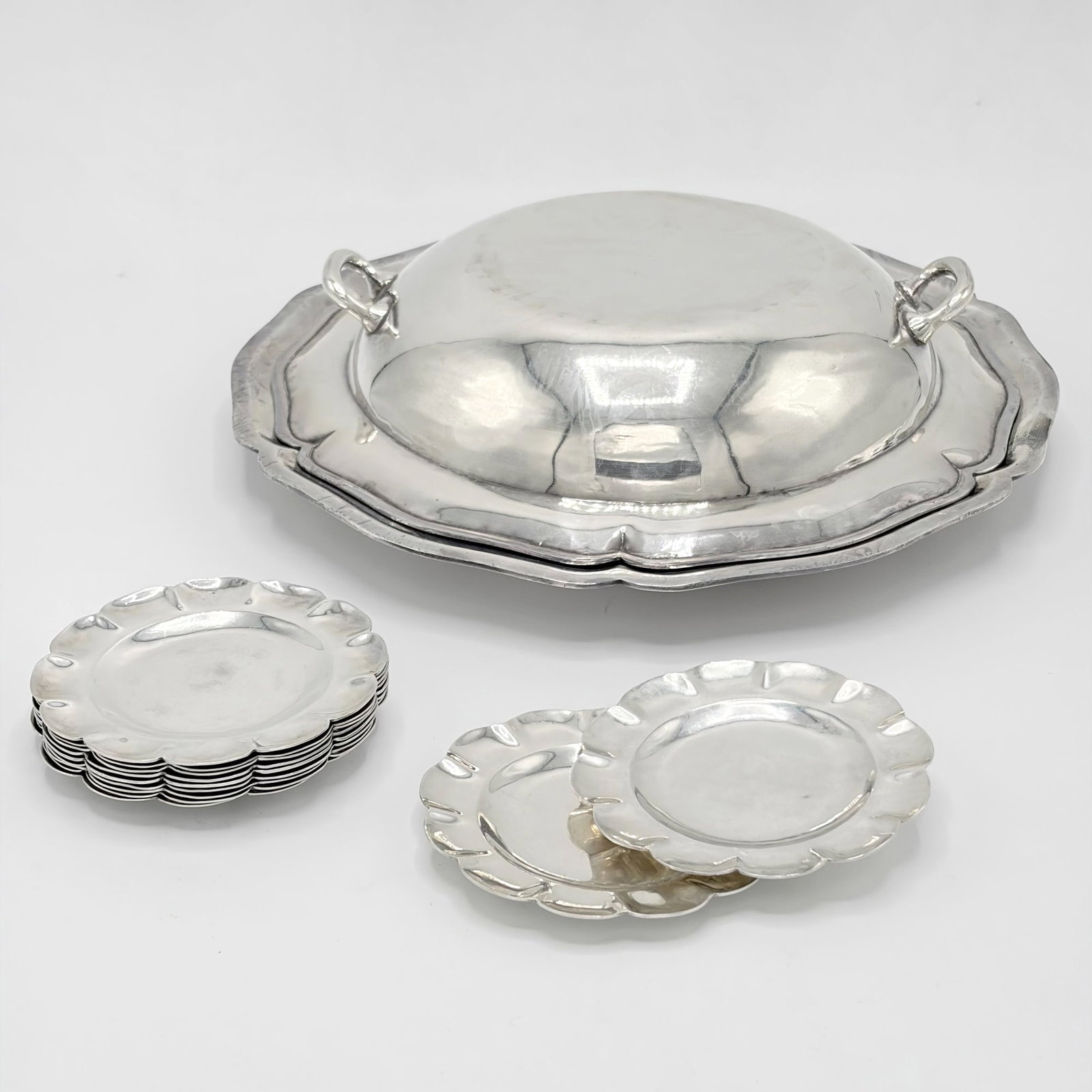 Mexican Sterling Silver Covered Dish and Set of Eleven Small Dishes: Sanborns, mid 20th century The covered dish shaped circular; the dishes with scalloped rims. Diameter of covered dish 10 inches, diameter of small dishes 3 1/2 inches, total approximately 43 ounces.