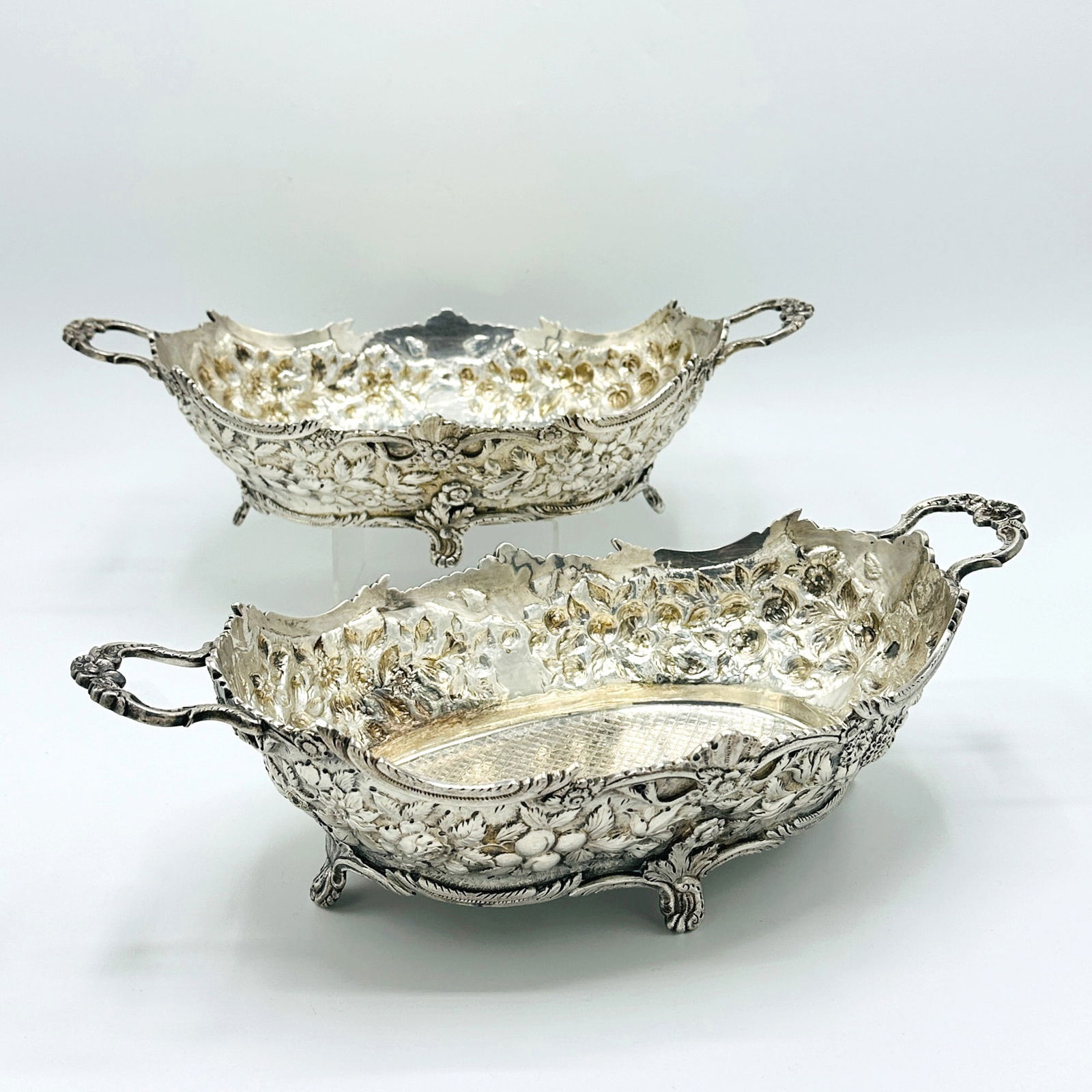 Pair of American Silver Baskets: S. Kirk & Son, Baltimore, second half 19th centuryEach oval chased overall with foliate scrolls, with loop handles, all raised on scrolling bracket feet. Length over handles 13 1/2 inches, total