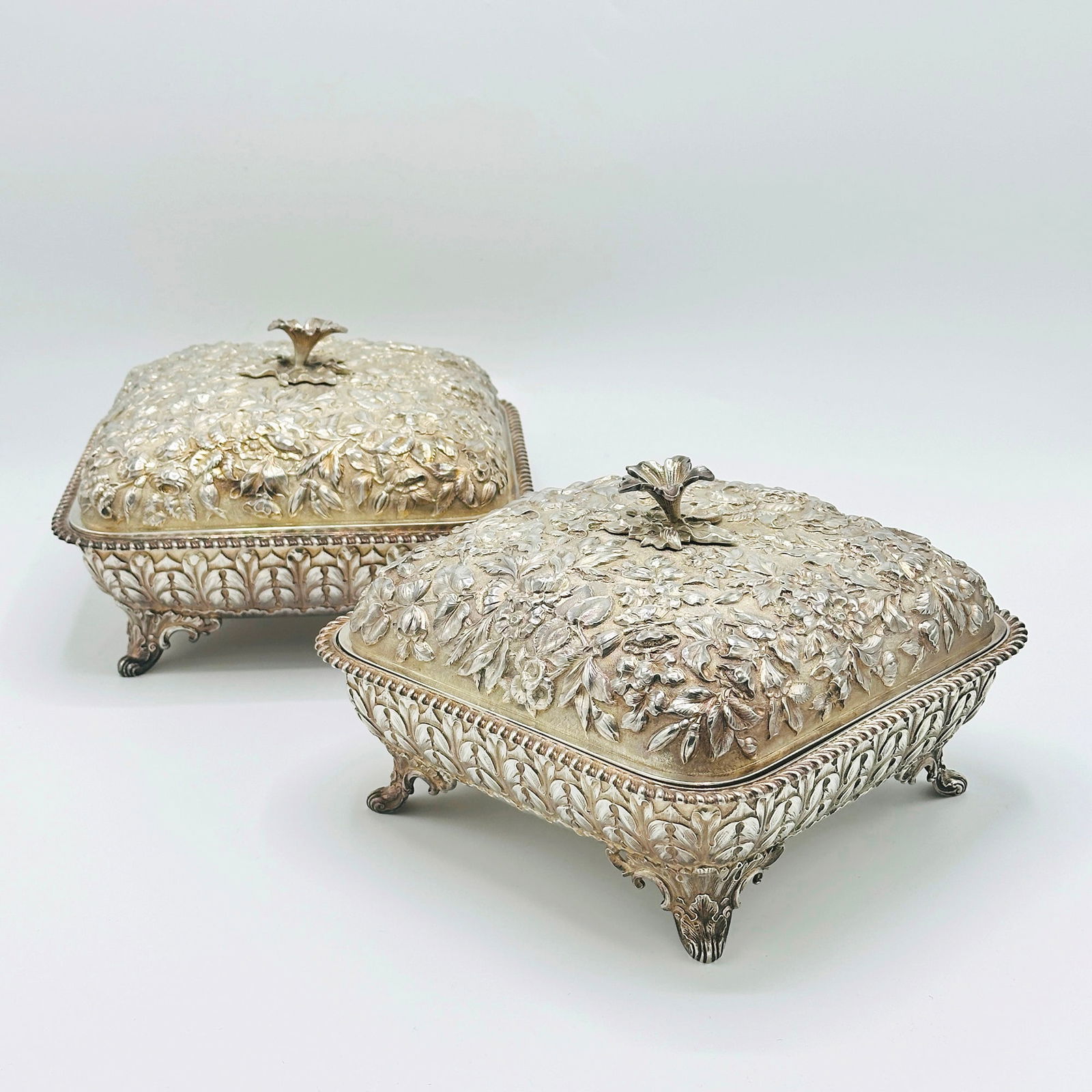 Pair of American Sterling Silver Covered Vegetable Dishes: Retailed by J. E. Caldwell & Co., Philadelphia, early 20th centuryEach square, chased overall with flowers and foliage, raised on bracket feet. Height 5 1/2 inches, 8 1/4 inches, square, total