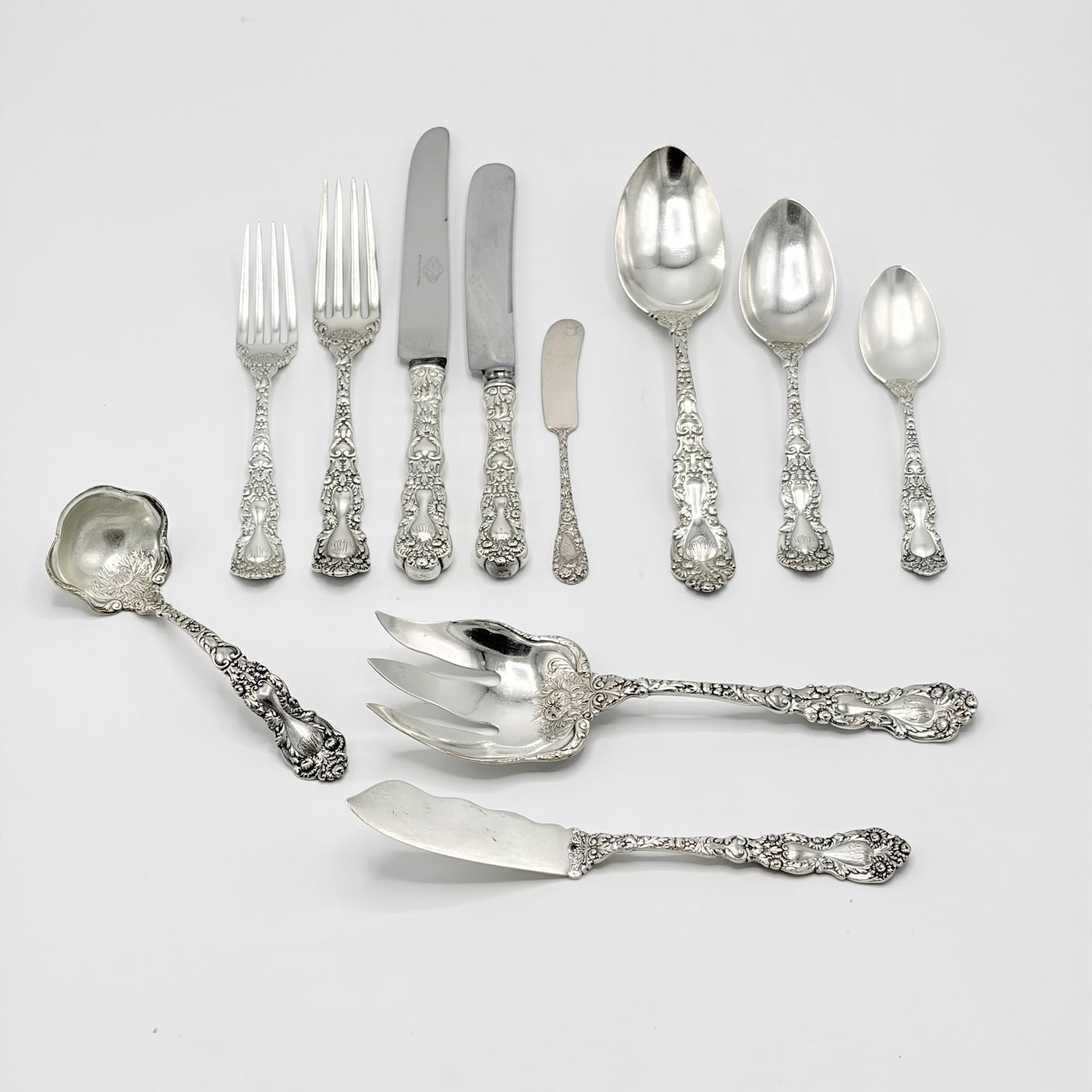 Gorham Sterling Silver "Imperial Crysanthemum" Pattern Flatware Service: Circa 1900 Comprising: Twelve dinner knivesTwelve lunch knivesEleven dinner forksEleven lunch forksEleven dessert spoonsTwelve tablespoonsFourteen teaspoonsEight butter knivesThr