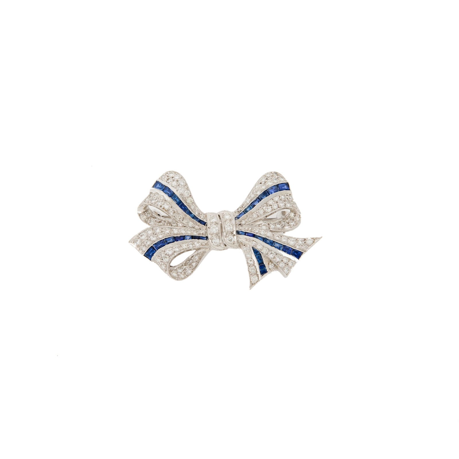 White Gold, Diamond and Sapphire Bow Brooch: 18 kt., 127 round diamonds ap. 1.35 cts., 30 calibre-cut sapphires, ap. 6.6 dwts. Diamonds: G-H-SISapphires: Medium slightly greyish blue, cleanish to slightly included.1 x 1 1/2 inches.