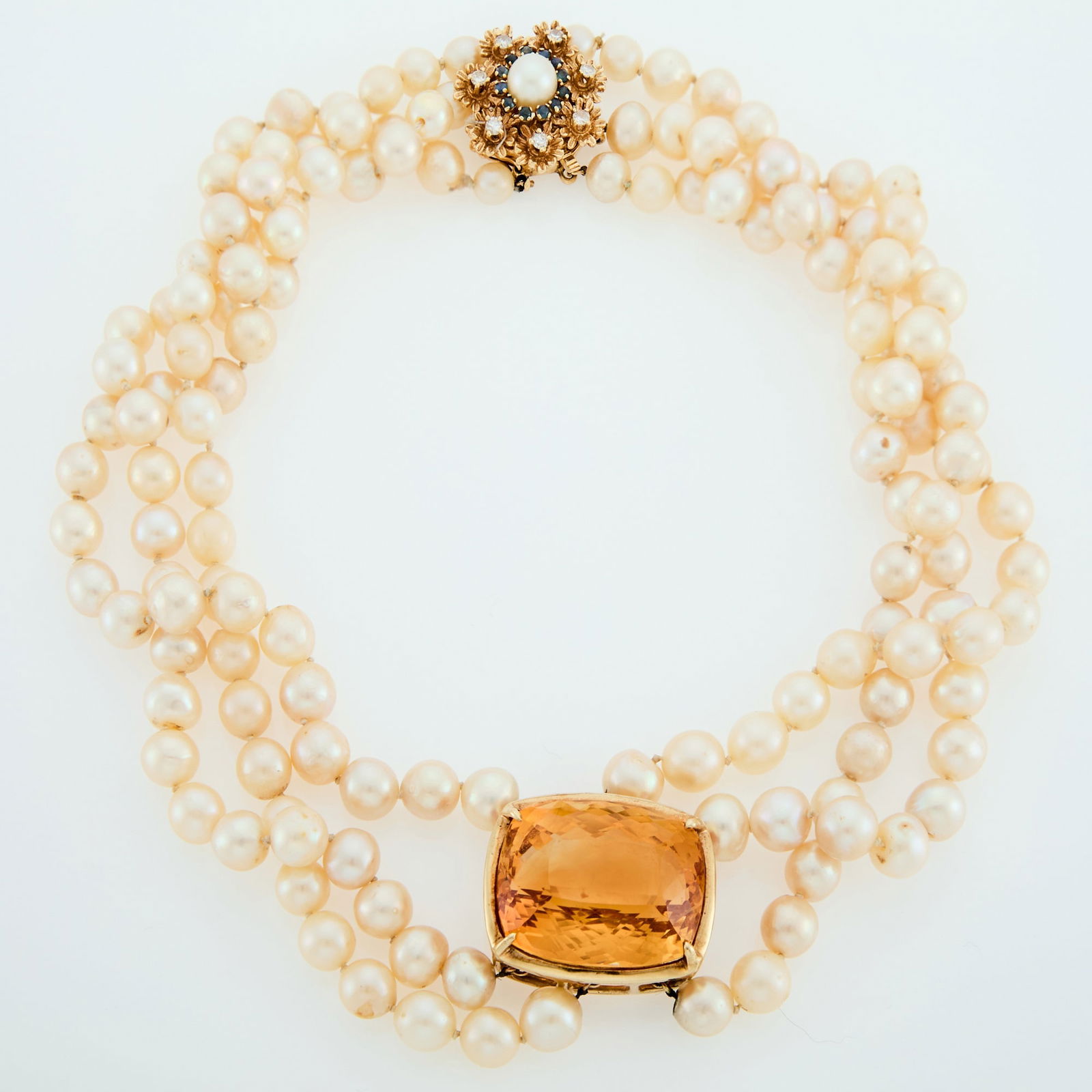 Triple Strand Cultured Pearl, Gold and Citrine Necklace with Gold, Cultured Pearl, Sapphire and: 14 kt., pearls ap. 8.8 to 5.7 mm., one cushion-shaped citrine ap. 83.00 cts., small round sapphires, round diamonds ap. .50 ct., ap. 88.5 dwts. gross. Length 17 1/2 inches. Pearls: creamy white with