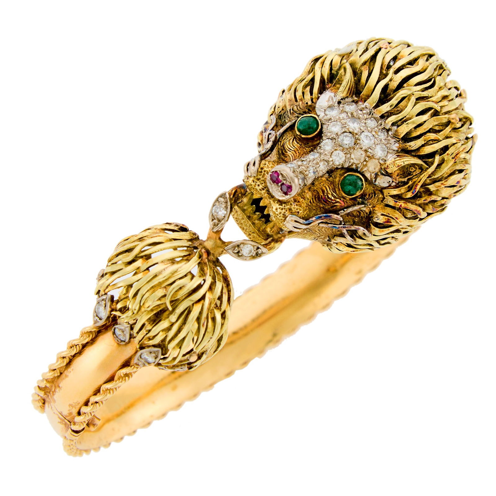 Two-Color Gold, Diamond, Cabochon Emerald and Ruby Lions Head Bangle Bracelet: 14 kt. yellow and white gold, round diamonds ap. .50 ct., 2 round cabochon emerald eyes, 2 small round rubies, ap. 26 dwts. Inner cir. 6 1/2 inches. Lion head width 7/8 inch. Bracelet width 5/16 inch