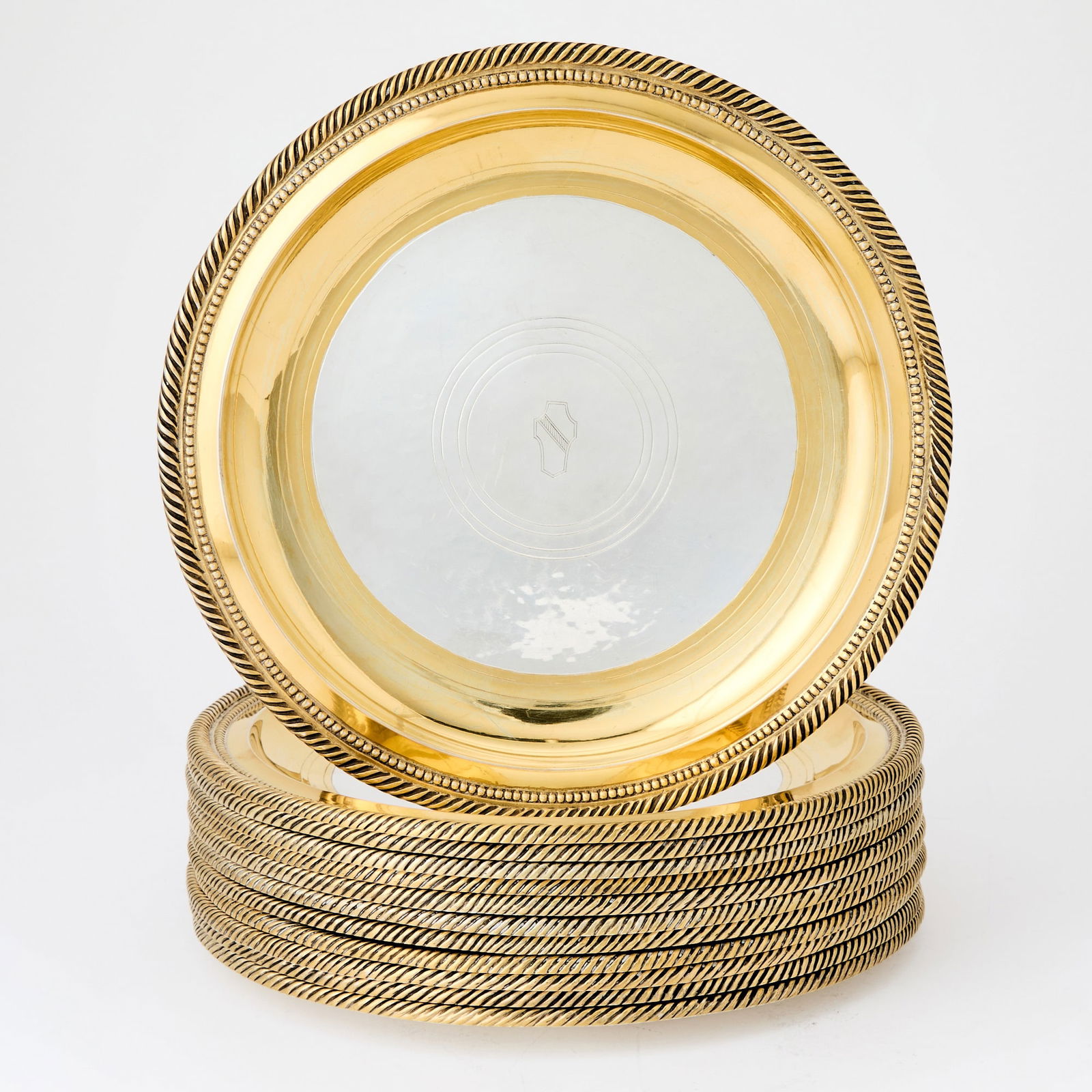 Set of Twelve American Parcel-Gilt Sterling Silver Dinner Plates: E. F. Caldwell & Co., New York, early 20th century With gilt border and rope-twist rim, the centers engraved with twelve different coats-of-arms, engraved on reverse E. F. Caldwell & Co. Sterl