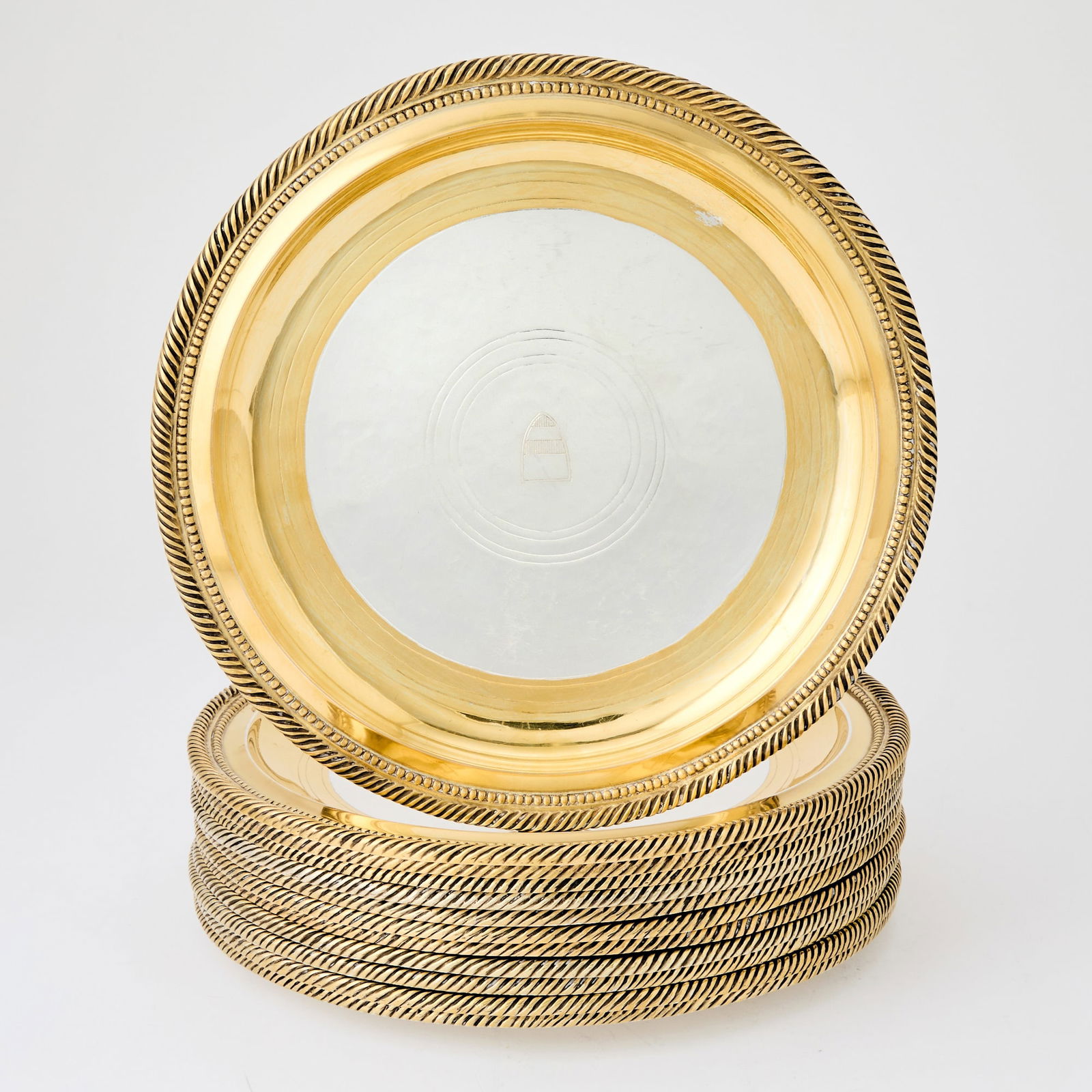 Set of Twelve American Sterling Parcel-Gilt Dinner Plates: 20th Century With gilt border and rope-twist rim, the centers engraved with twelve different coats-of-arms, engraved on reverse E. F. Caldwell & Co. Sterling New York, diameter 10 1/4 inches, tota