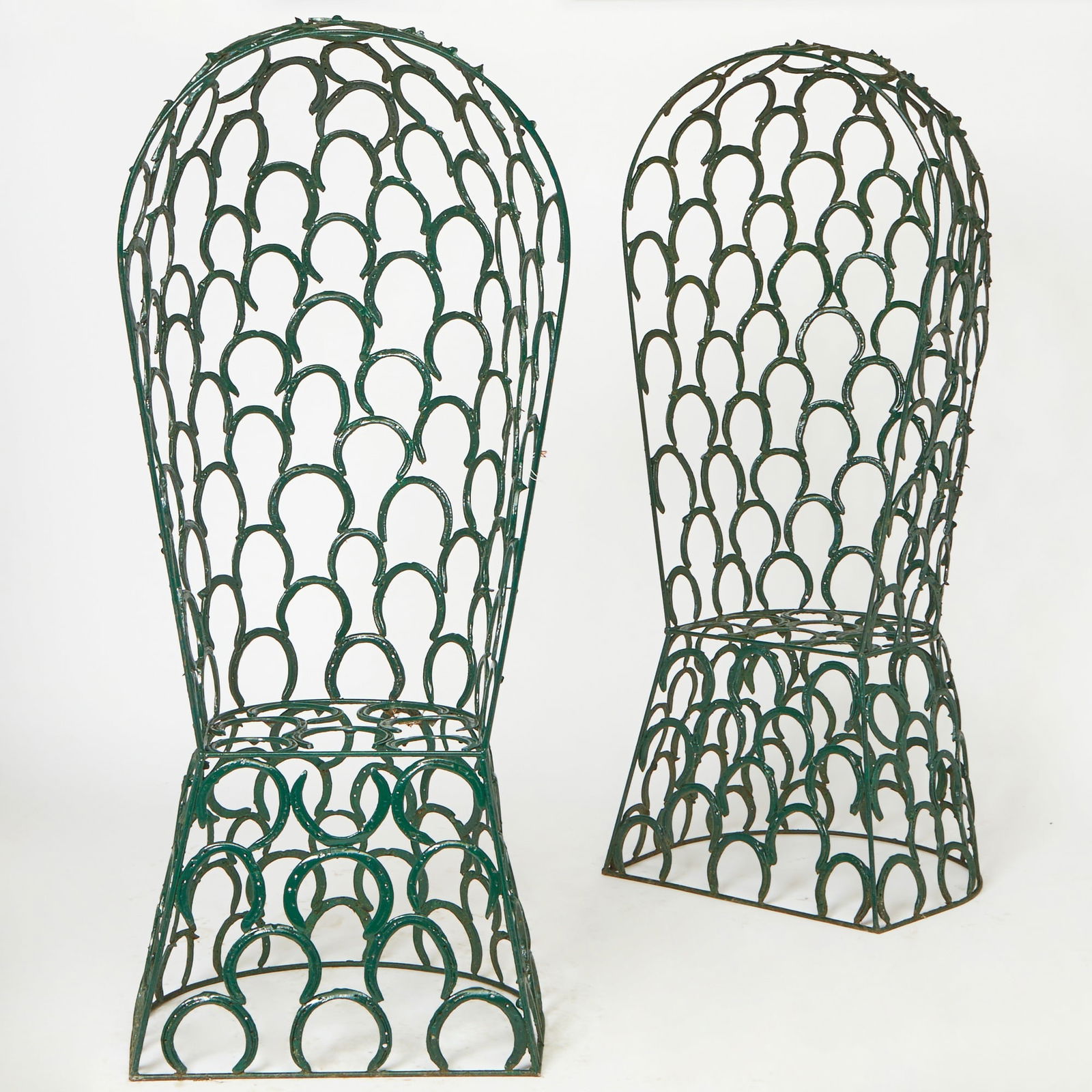 Pair of Green Painted Metal Horseshoe Garden Chairs: Made with several horseshoes welded together. Height 86 inches, width 26 inches, depth 17 1/2 inches.