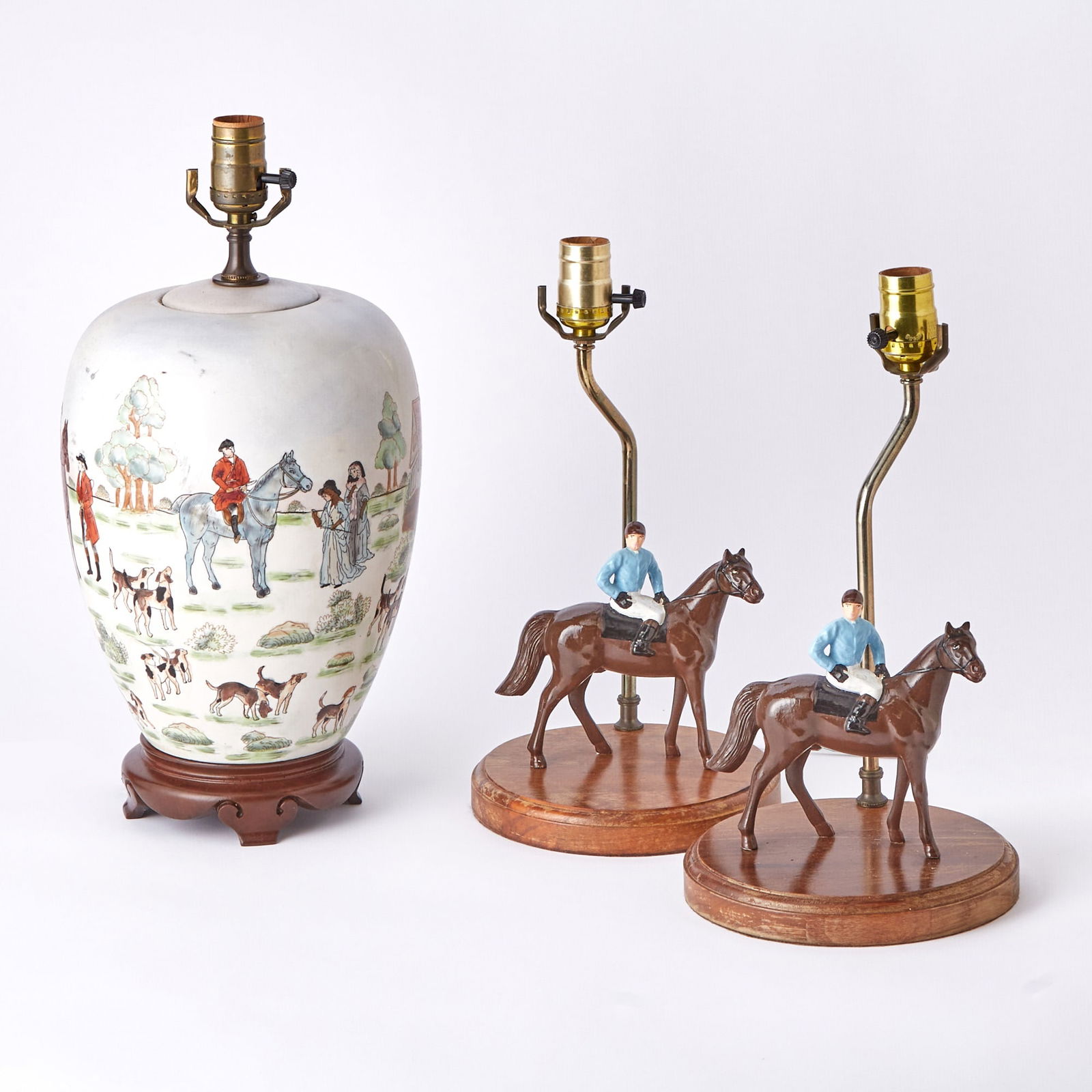 Pair of Painted Metal Horse and Jockey Table Lamps: Each with the Whitney Stables silks, on a circular wood base, height of body 6 1/4 inches; Together with a Porcelain Hunt Theme Table Lamp. Height of body 10 1/2 inches.