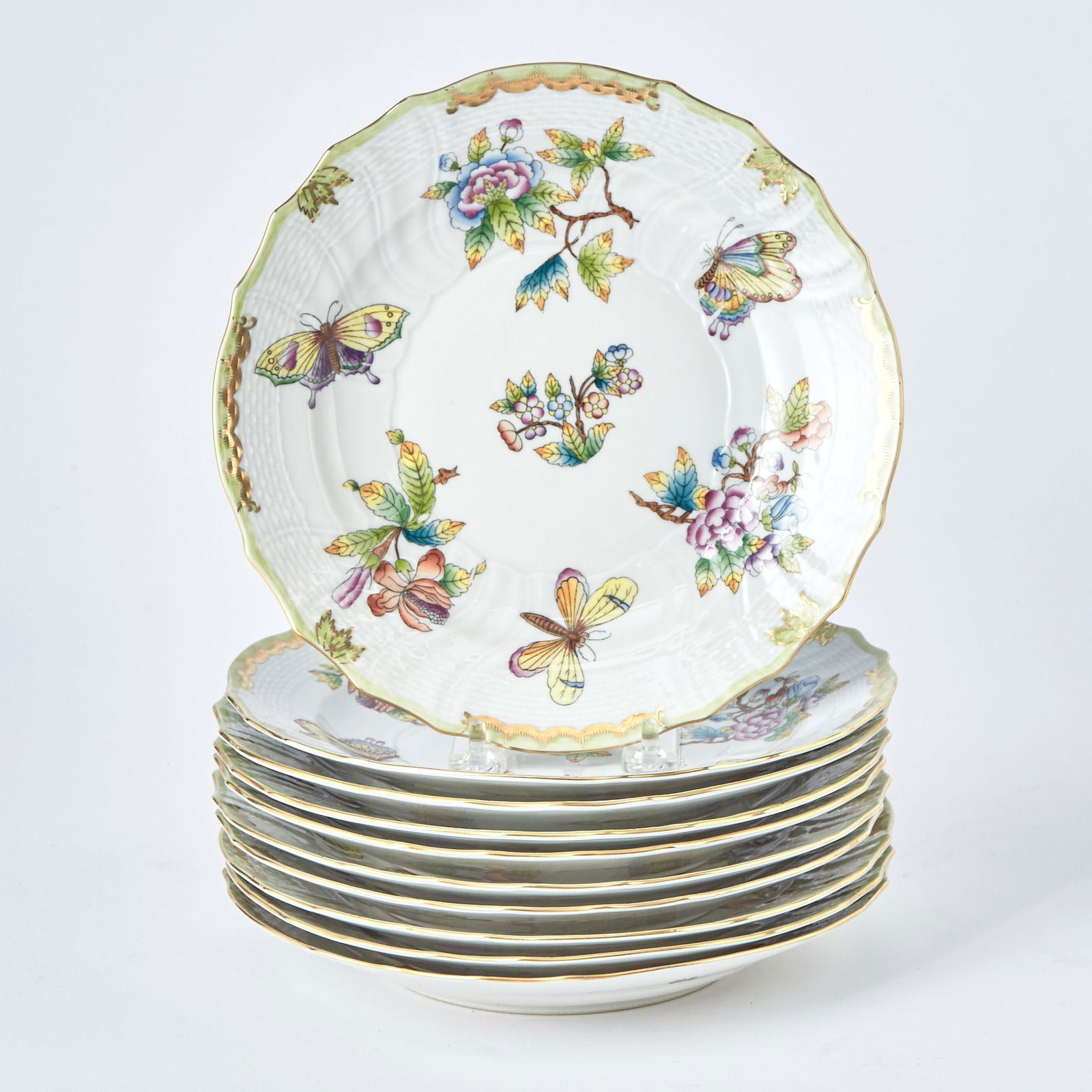 Set of Ten Herend Porcelain "Queen Victoria" Pattern Luncheon Plates: Each with a green border.Diameter 9 inches.(10) One plate has a spider web shaped hairline fracture to its center, more visible when examined from the underside; otherwise, each plate appears to be