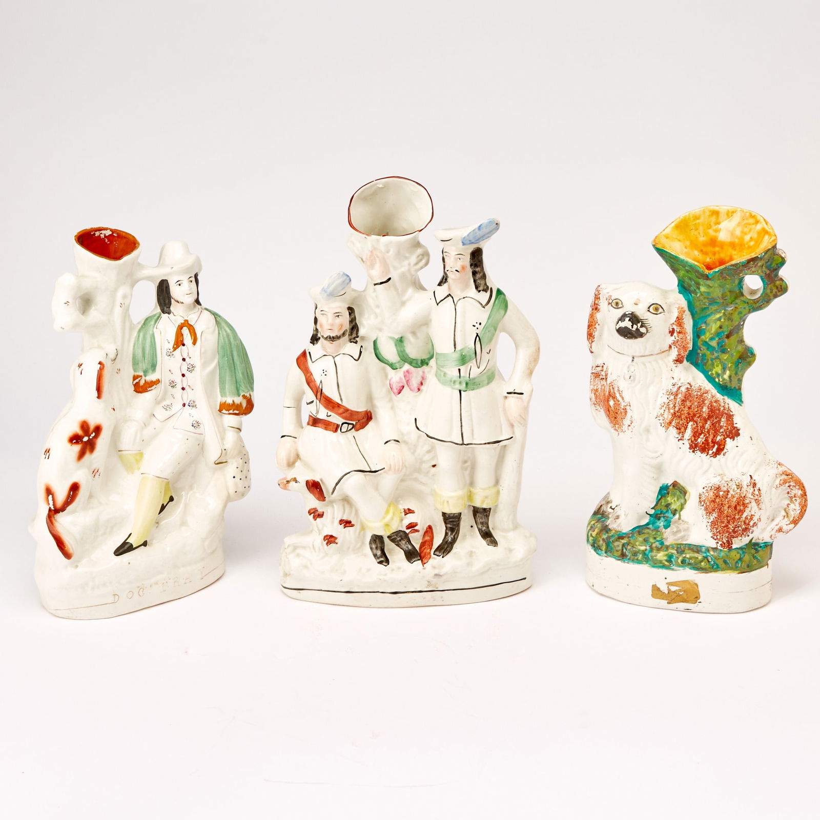 Group of Three Large Staffordshire Pottery Figural Spill Vases: Comprising a group modeled as Little John and Robin Hood with a dog, height 14 1/2 inches, width 9 inches; an example titled Dog Tray, and another example modeled as a spaniel.