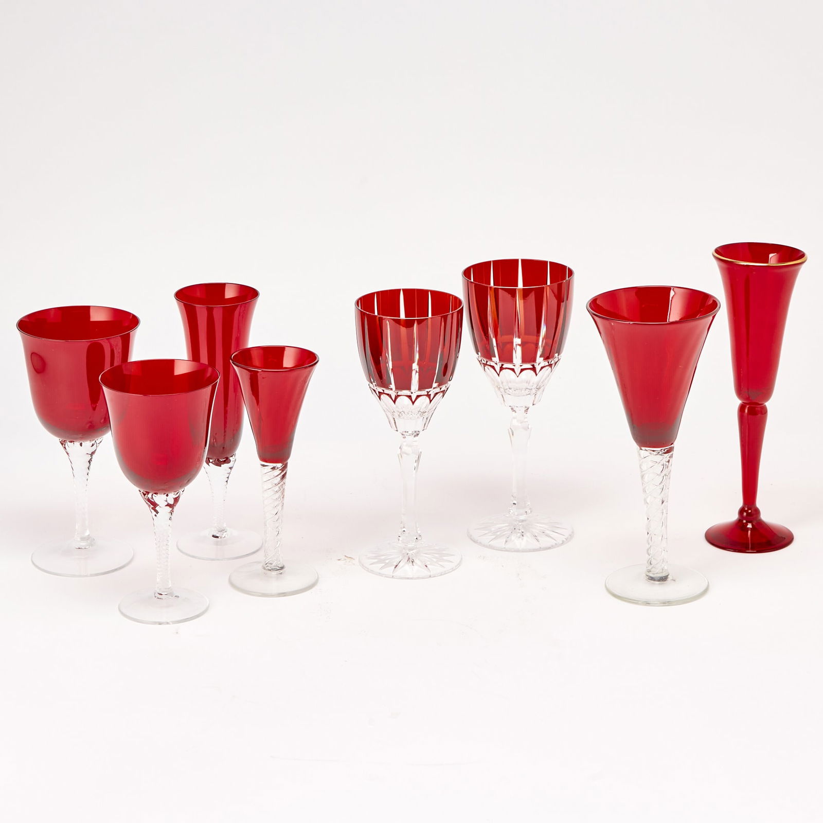 Assembled Group of Ruby and Colorless Glass Stemware: Comprised of four part sets, each set unmarked; comprising one set of twenty-three glasses, in two sizes, each glass with a conical bowl and spiral air twist stem, height of taller 9 inches (eleven ex