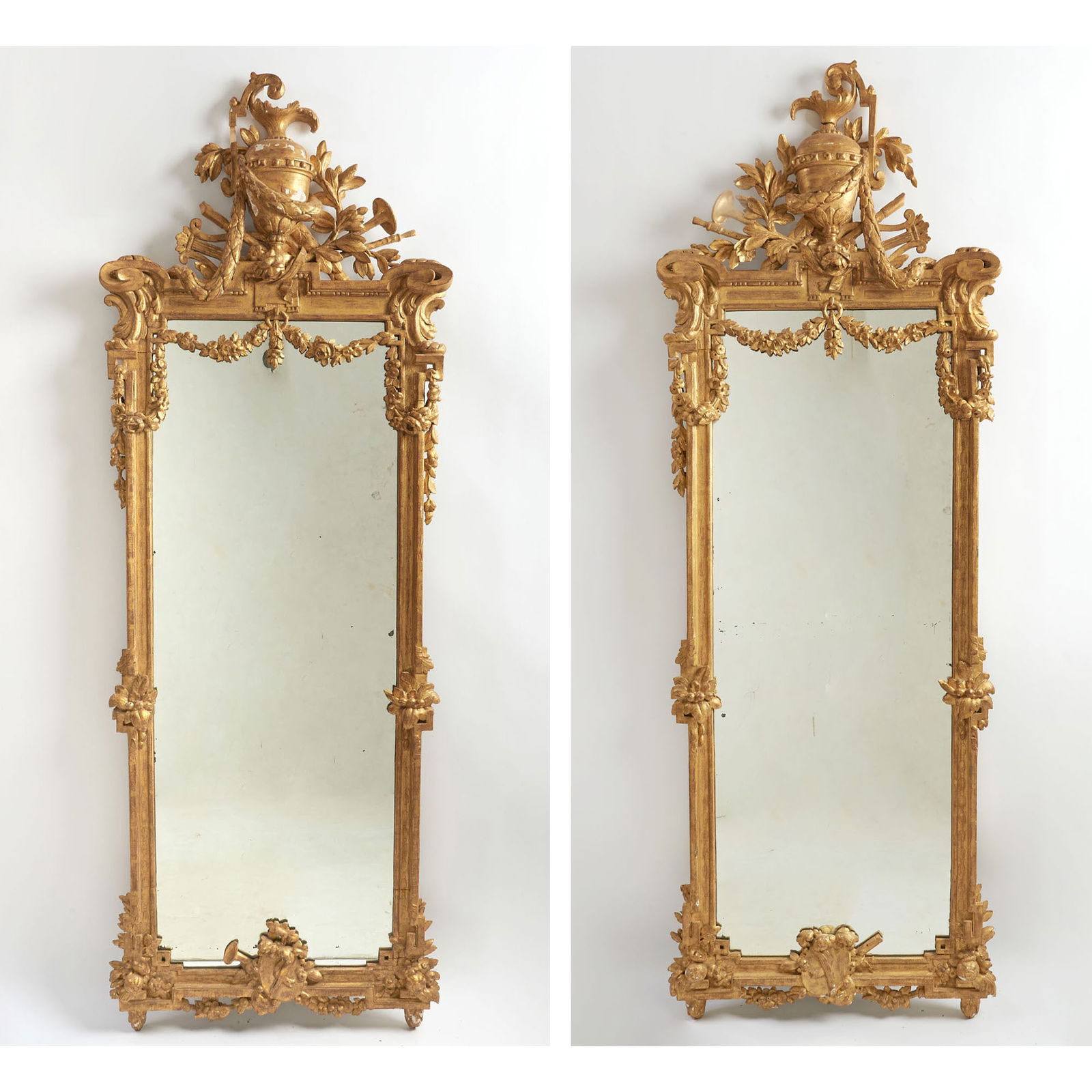 Pair Louis XVI Style Carved and Giltwood Pier Mirrors: Late 19th century Height of each 85 inches, width 30 inches. lacking some carving
