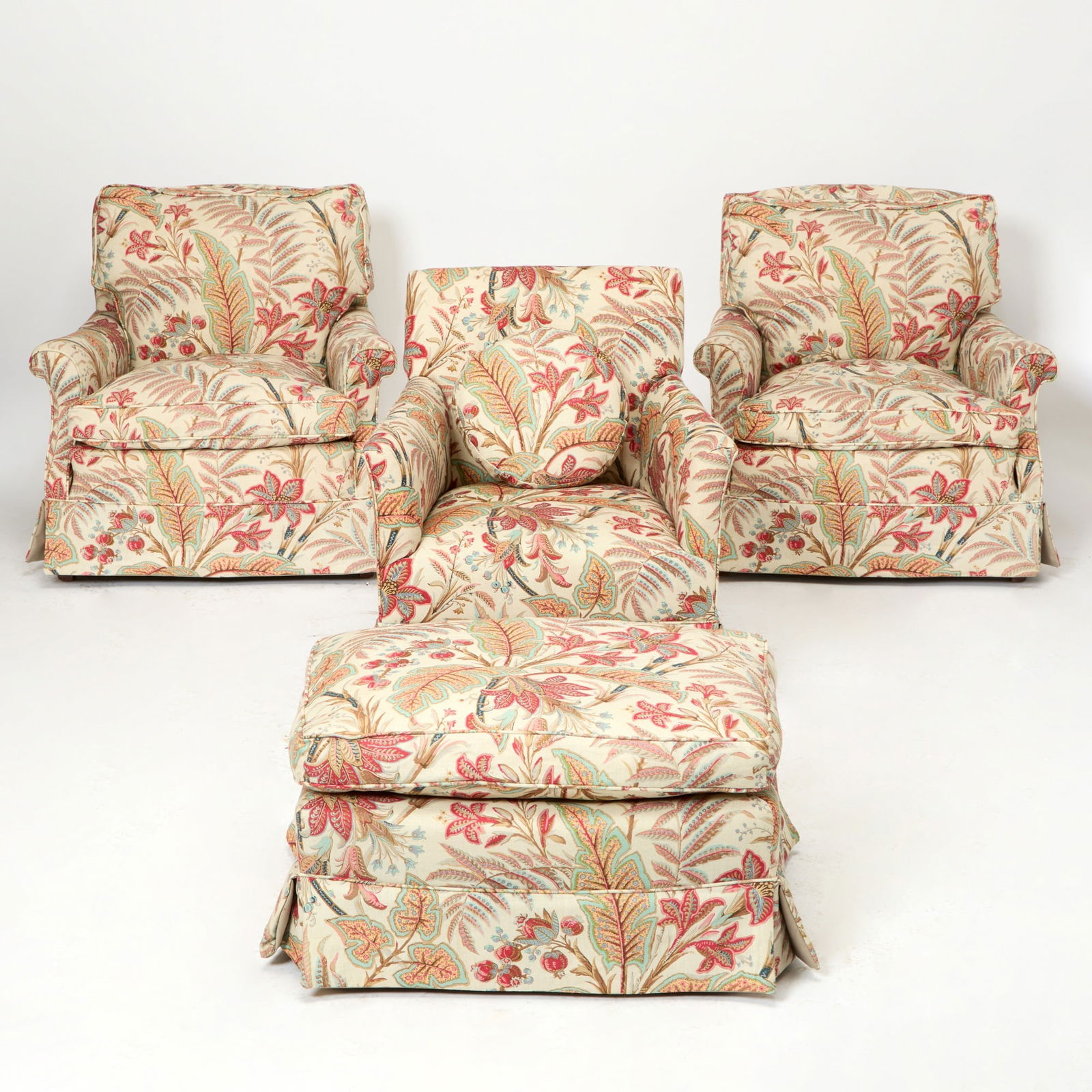 Three Upholstered Club Chairs and an Ottoman: 20th Century With three pillows. Height of pair of chairs 30 inches, width 33 inches, depth 36 inches; height of single chair 31 inches, width 28 inches, depth 28 inches; height of ottoman 16 inches,