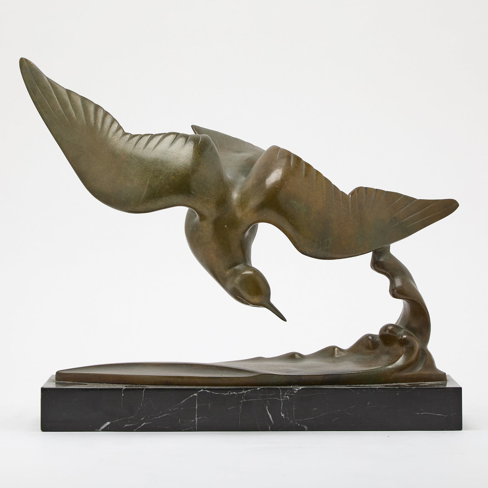 Art Deco Patinated Bronze Figure of a Seabird in Flight: Cast from a model by J.B. Leonard, circa 1930 Modeled in flight above a wave, on a rectangular white-veined black marble base, inscribed J.B. Leonard BRONZE.Height overall 13 3/4 inches, length 17