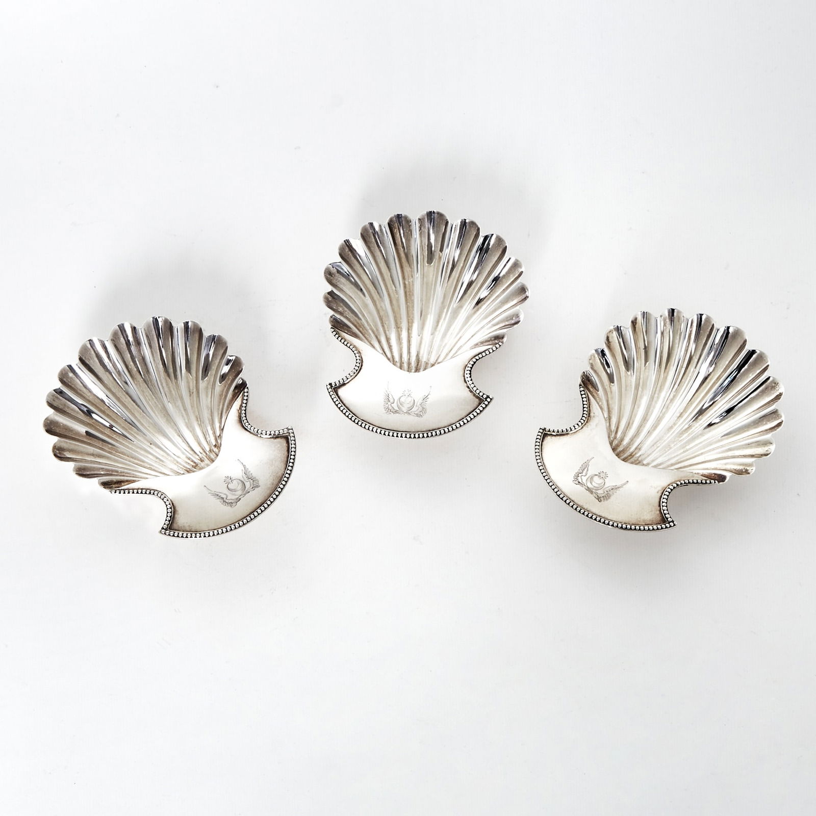 Set of Three George III Sterling Silver Butter Shells: Hester Bateman, London, 1785 Each scalloped body with flat handle engraved with crest, raised on three shell-form feet. Length 6 inches, total approximately 10 ounces. Provenance: William Walter, Lond
