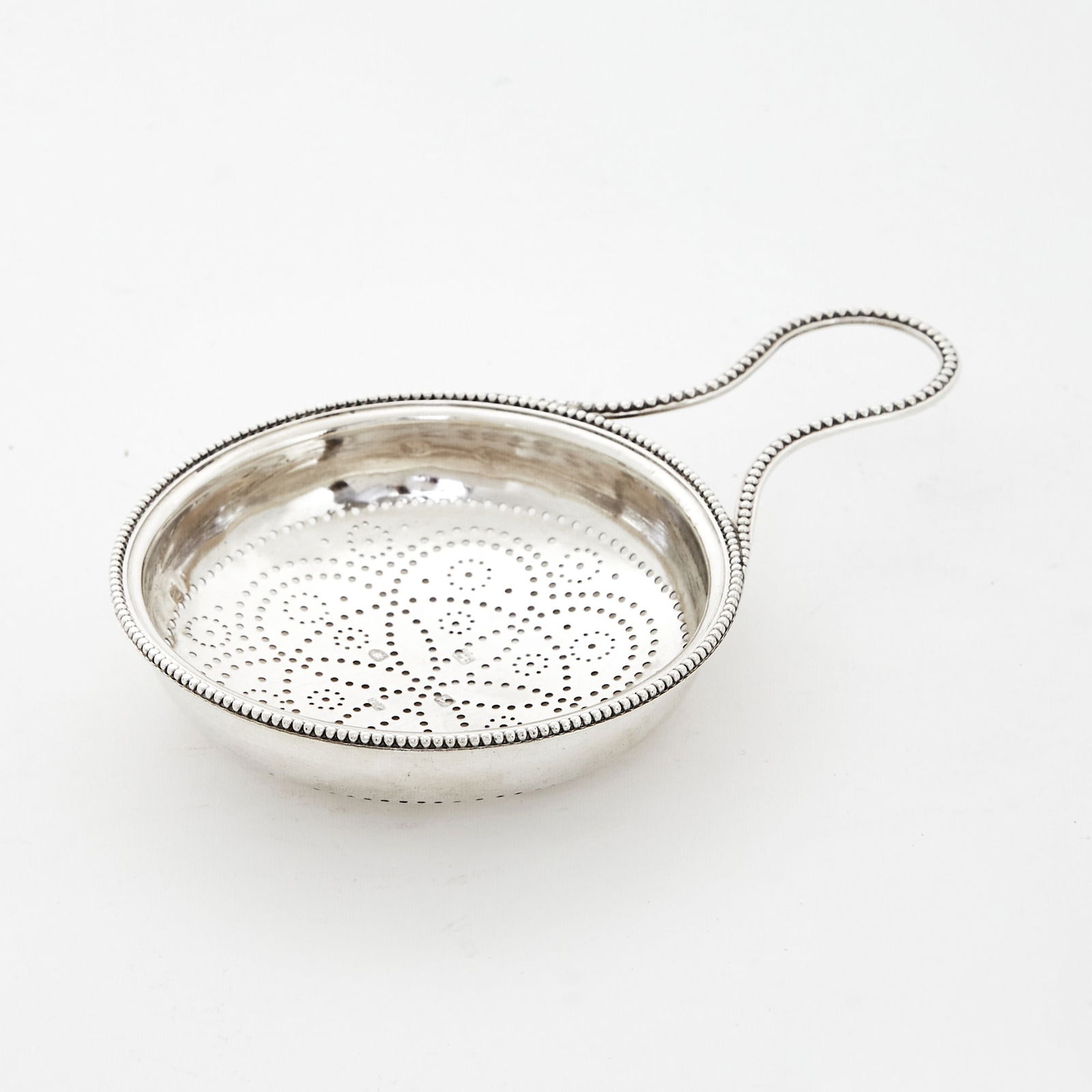 George III Sterling Silver Punch Strainer: Hester Bateman, London, 1783 Circular with beaded rim and loop handle. Length over handle 7 inches, approximately 3 ounces. Generally good condition overall; clearly hallmarked