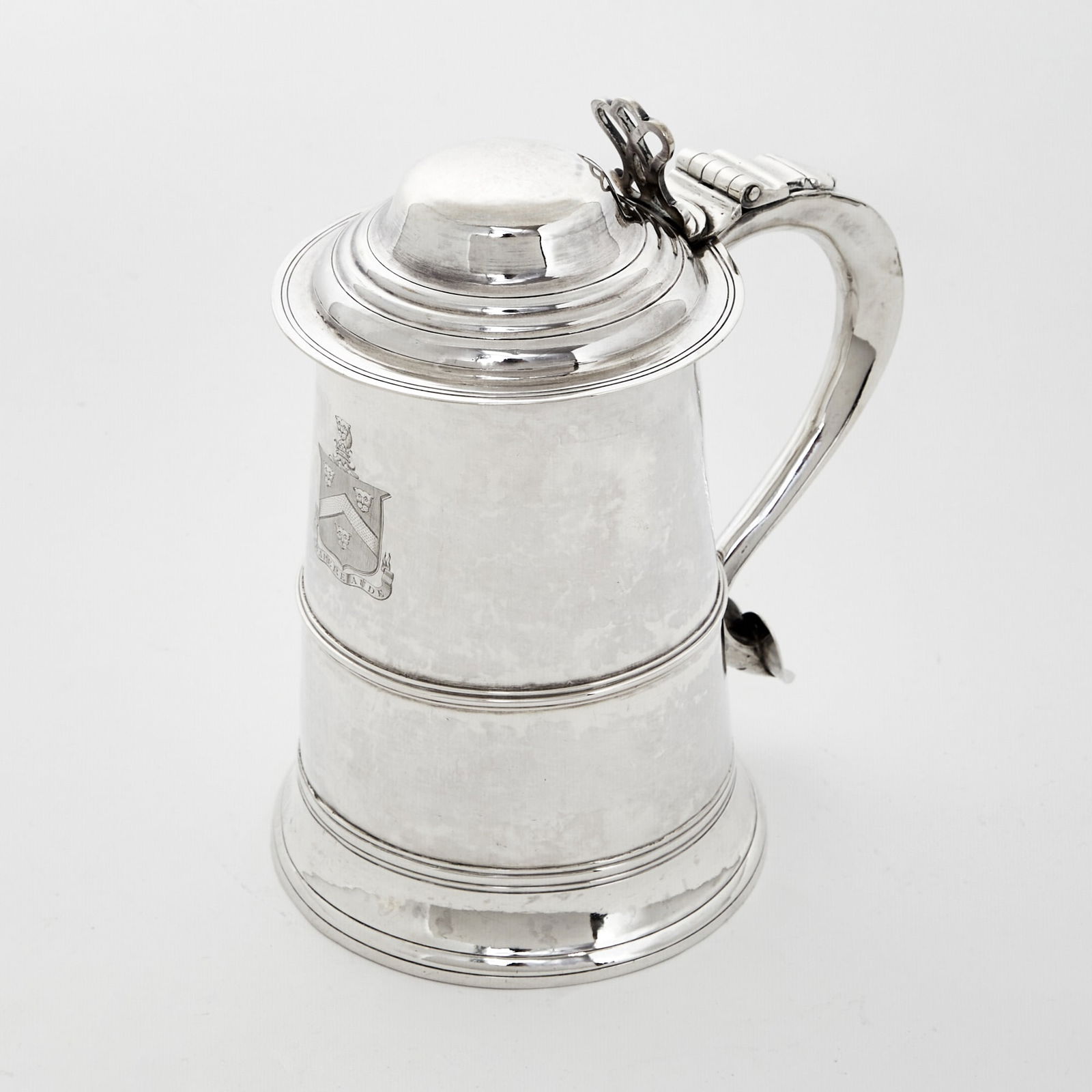 George III Sterling Silver Covered Tankard: Hester Bateman, London, 1784 Cylindrical with molded band at waist and spreading foot, with domed cover and scroll handle. Height 8 1/4 inches, approximately 25 ounces. Provenance: I. Franks, London,