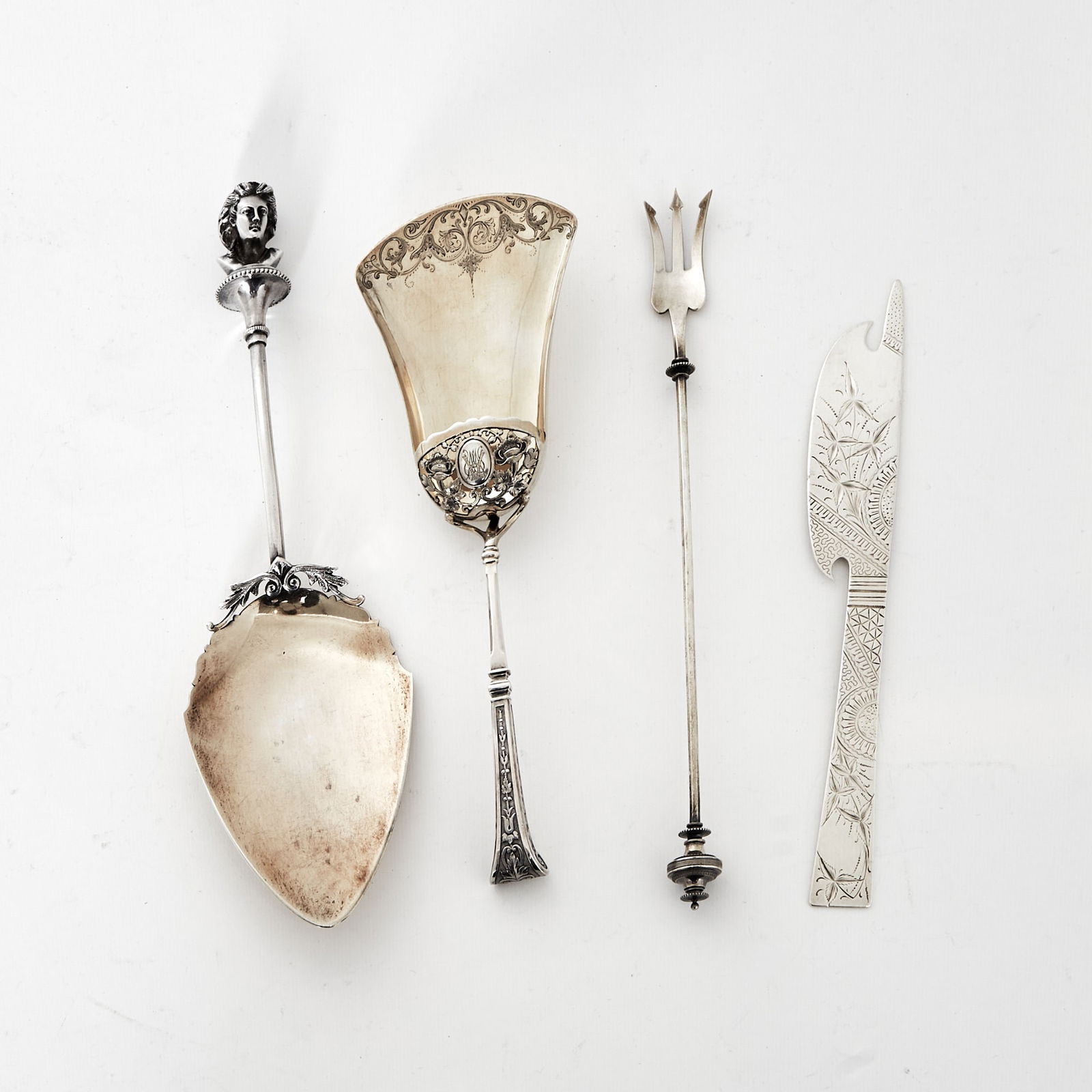Four American Sterling Silver Serving Utensils: Comprising:Dessert server with figural finial, length 10 1/4 inches Hooded serving spoon, length 9 inches Pickle fork, length 9 1/2 inches Knife, length 8 inchesTotal approximately 9 ounces. 