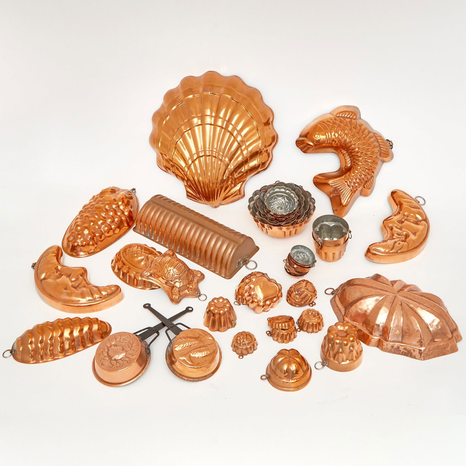Group of Copper Moulds: Including fish, crescent moon, shell examples, etc. Approximately 44 pieces. Largest shell 12 inches, diameter of smallest 2 inches.