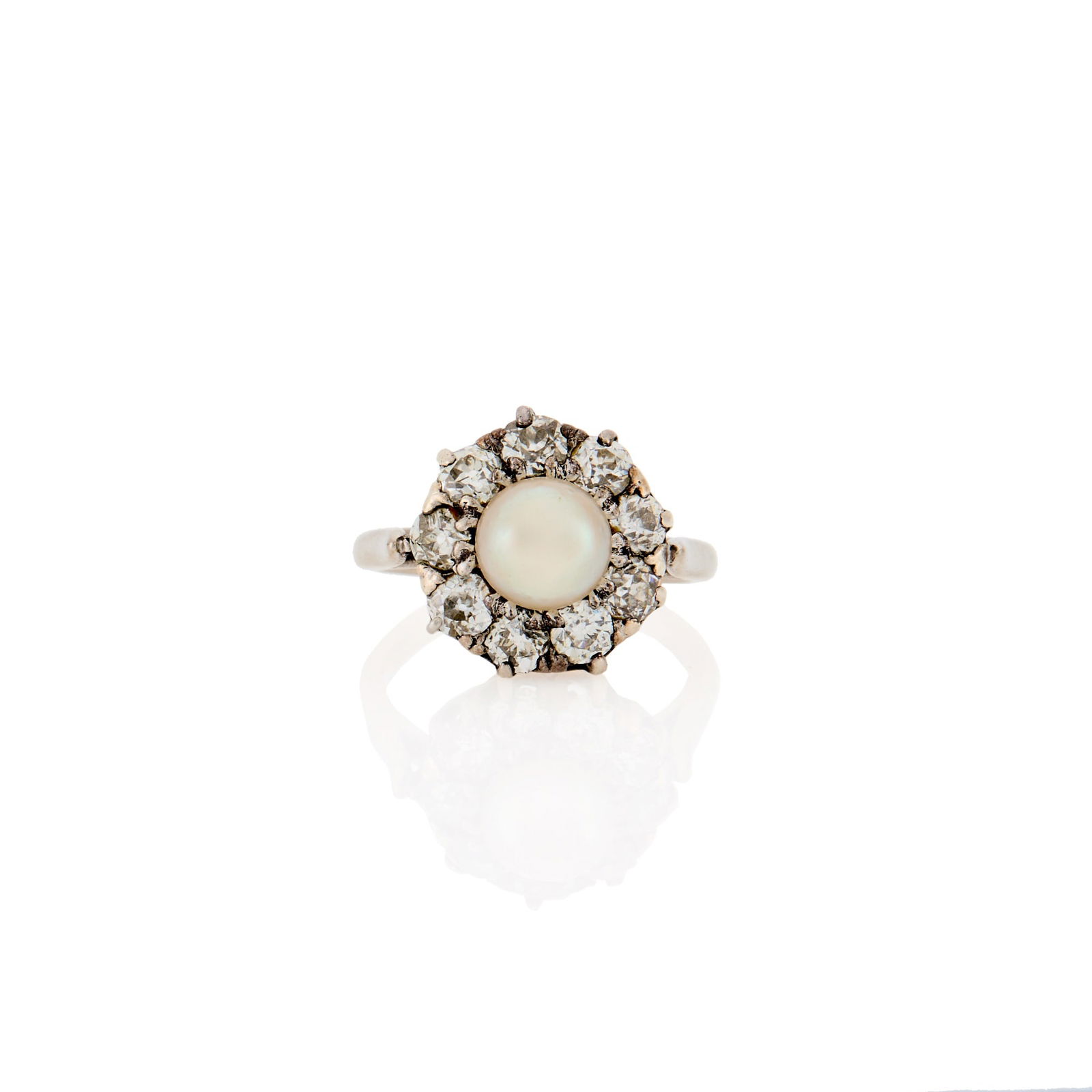 White Gold, Pearl and Diamond Ring: 9 old European-cut diamonds ap. 1.05 cts., one pearl ap. 6.9 mm., ap. 2.8 dwts. Size 4 1/2.The pearl has not been tested. Tests as 14 kt.Pearl: slightly creamy white with green and rose undertones,