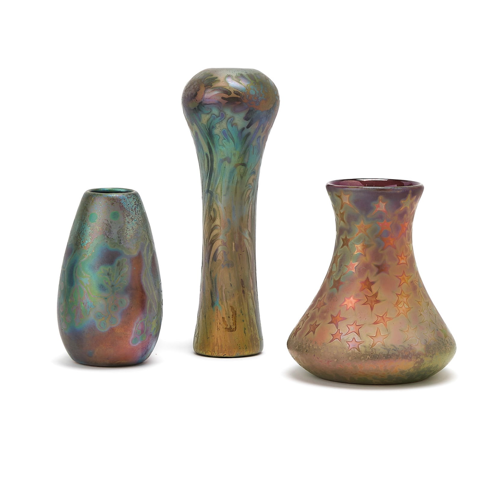 Group of Three Weller Sicard Art Nouveau Iridescent Art Pottery Vases: Early 20th century Comprising an ovoid example, decorated with pendant branches, leaves and berries, signed SICARD WELLER, height 5 1/2 inches; a tall flower-form example with a bulbous shoulder and s