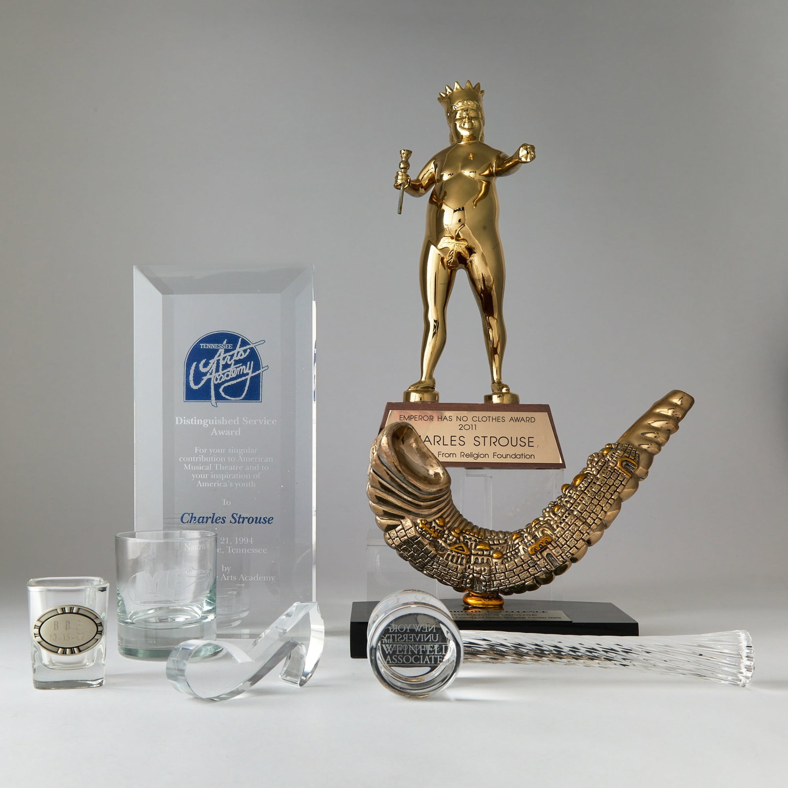 Awards presented to Charles Strouse: CHARLES STROUSE Awards presented to Charles Strouse, with four other items. Glass awards and three metal ones mounted on a base, largest measuring 13 x 5 x 2 inches (33 x 13 x 5 cm).