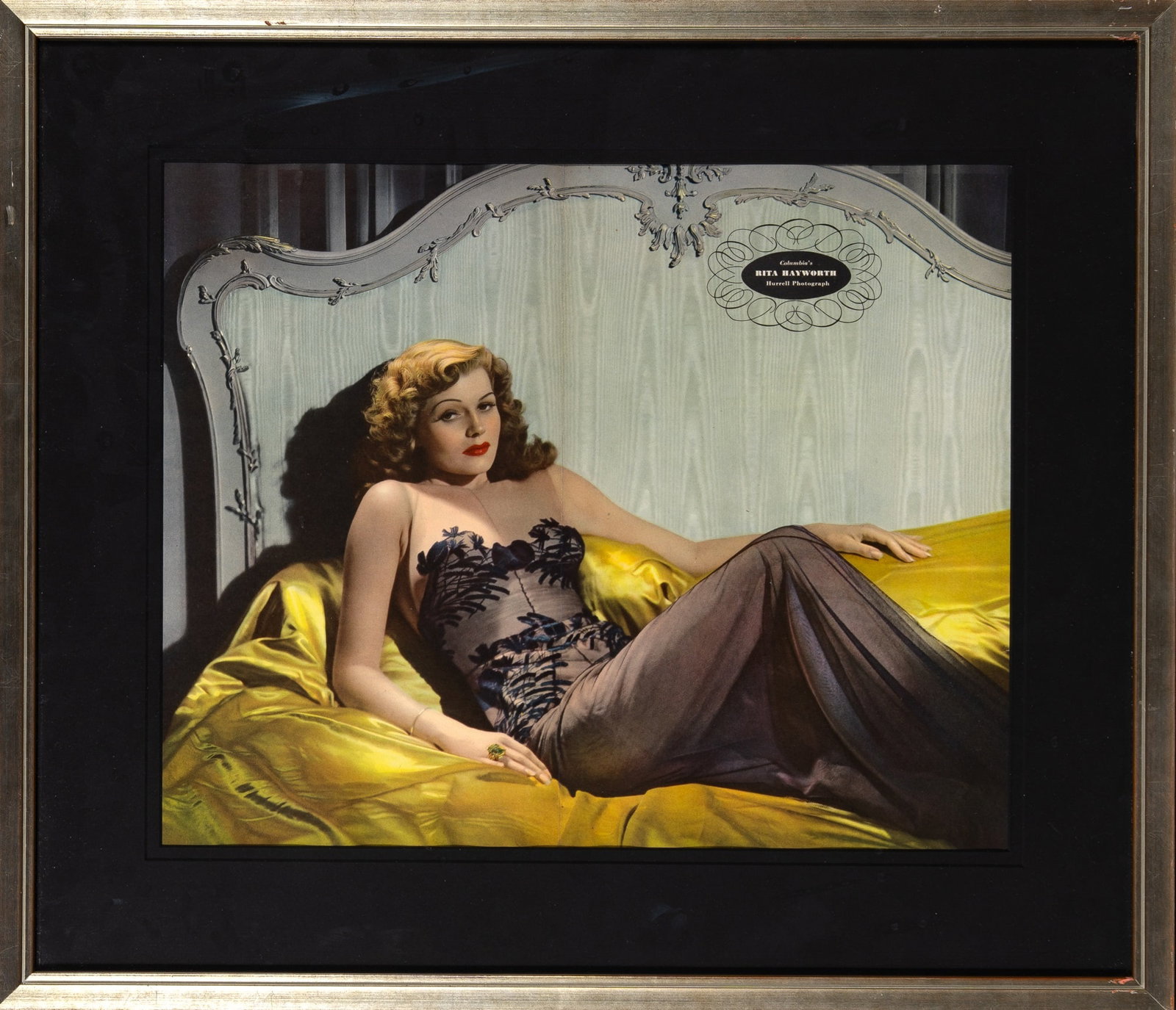 A Rita Hayworth photograph by George Hurrell published in Esquire: [RITA HAYWORTH, GEORGE HURRELL] Rita Hayworth photograph by George Hurrell. Published in Esquire, November 1942. Color print. Matted and framed. 14 1/4 x 17 inches (36 x 43 cm), in frame 20 1/2 x 24