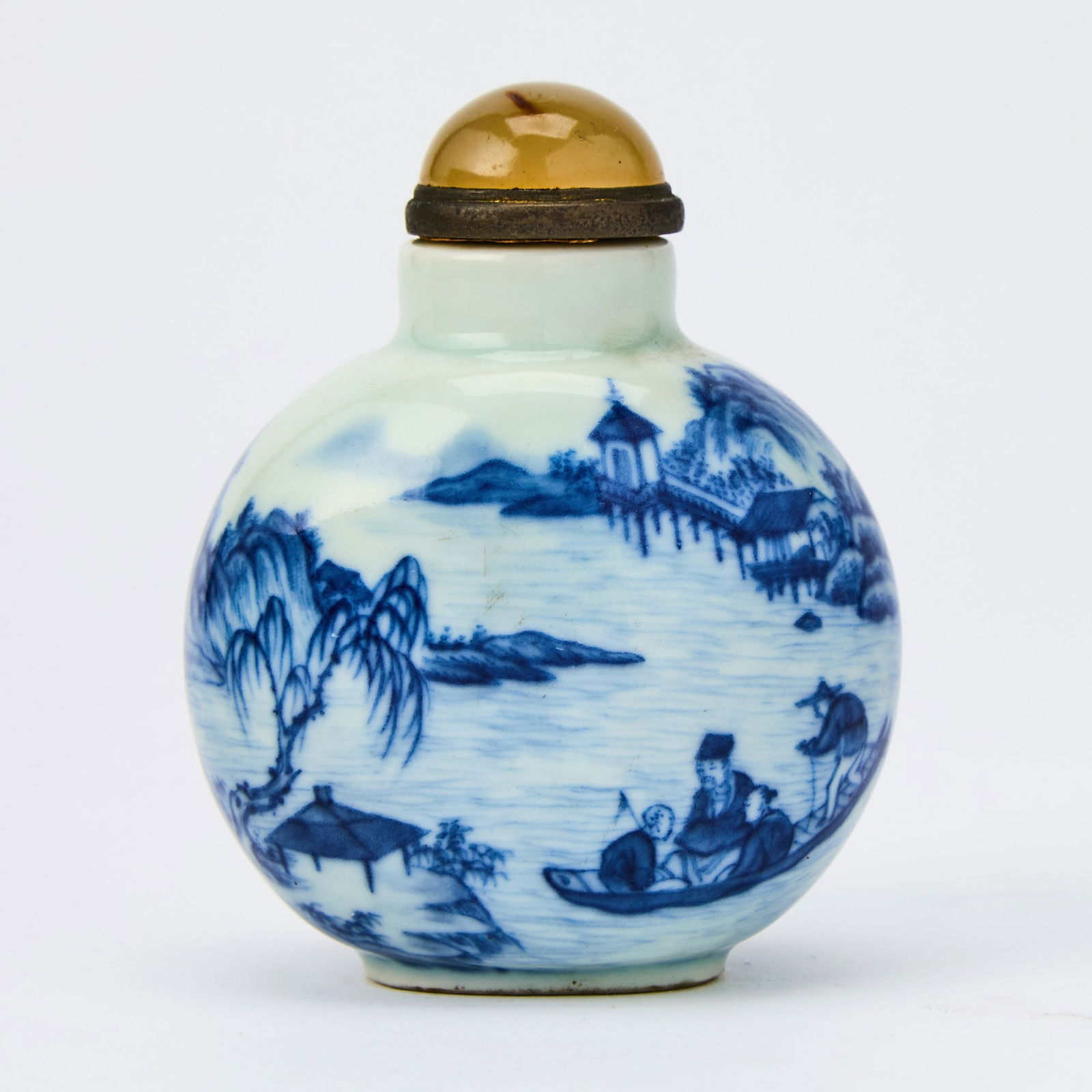 A Chinese Blue and White Porcelain Snuff Bottle 19th Century: Of flattened, rounded form; decorated with a continuous scene depicting scholars sailing on a boat within a waterside and mountainous landscape. (Height 3 1/4 inches)