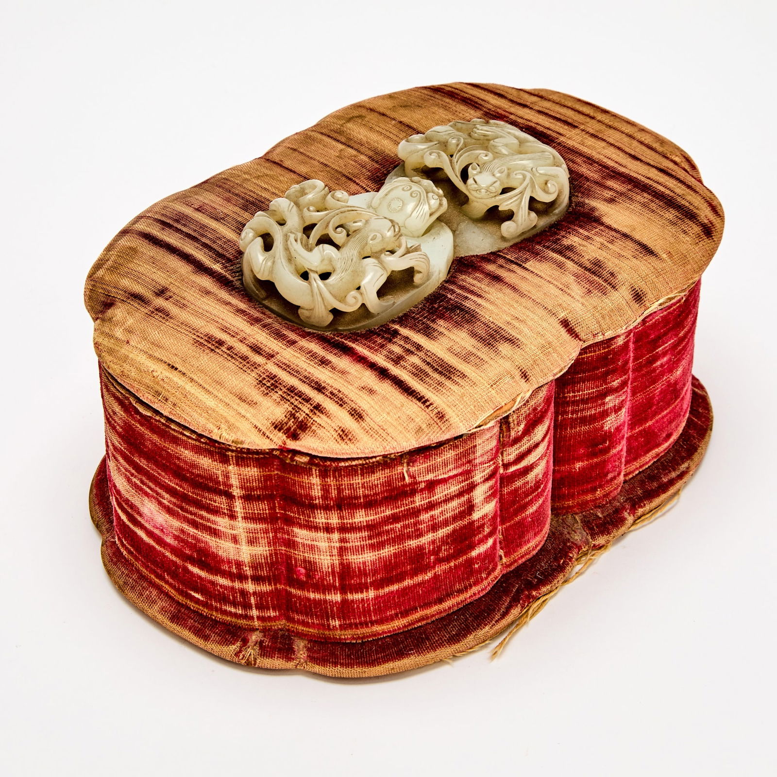 A Continental casket Box set with Chinese White Jade Buckle Jade Yuan-Ming Dynasty: The two-part buckle carved with openwork qilong in high relief and with qilong-head hook; the shaped oval box covered in worn silk velvet. (Length of jade 4 1/4 inches)