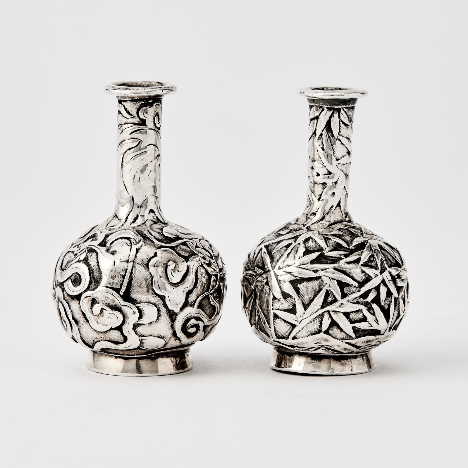 A Rare Pair of Chinese Export Miniature Silver Vases Mark of Wang Hing, 19th Century: Each decorated with a writhing stylized dragon in flight amidst scrolling clouds. Combined Weight 1.25 ozt. (Height 2 inches)