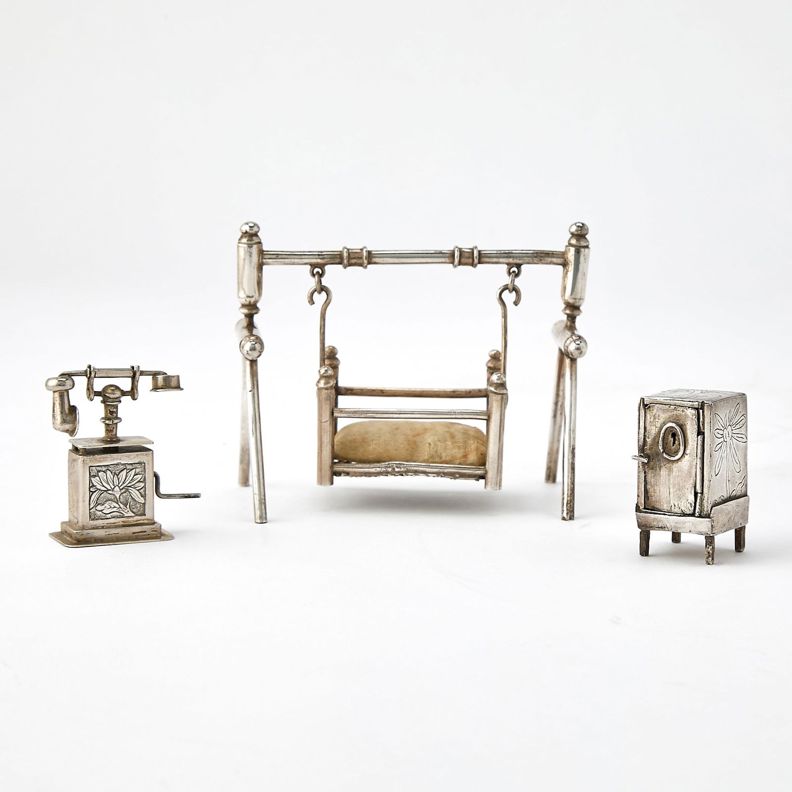 Three Rare Chinese Export Silver Miniature Articles Late 19th Century: Comprising a cradle, an icebox, and a telephone. Combined Weight 3.05 ozt. (Height of largest 3 inches)