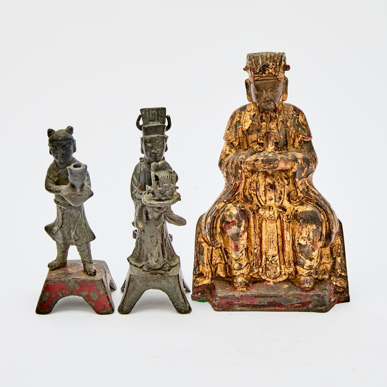Three Chinese Cast Bronze Daoist Figures Ming Dynasty: Comprising a gilt lacquered seated Wenchang, a standing boy attendant, and a standing male attendant. (Height of tallest 6 1/2 inches)