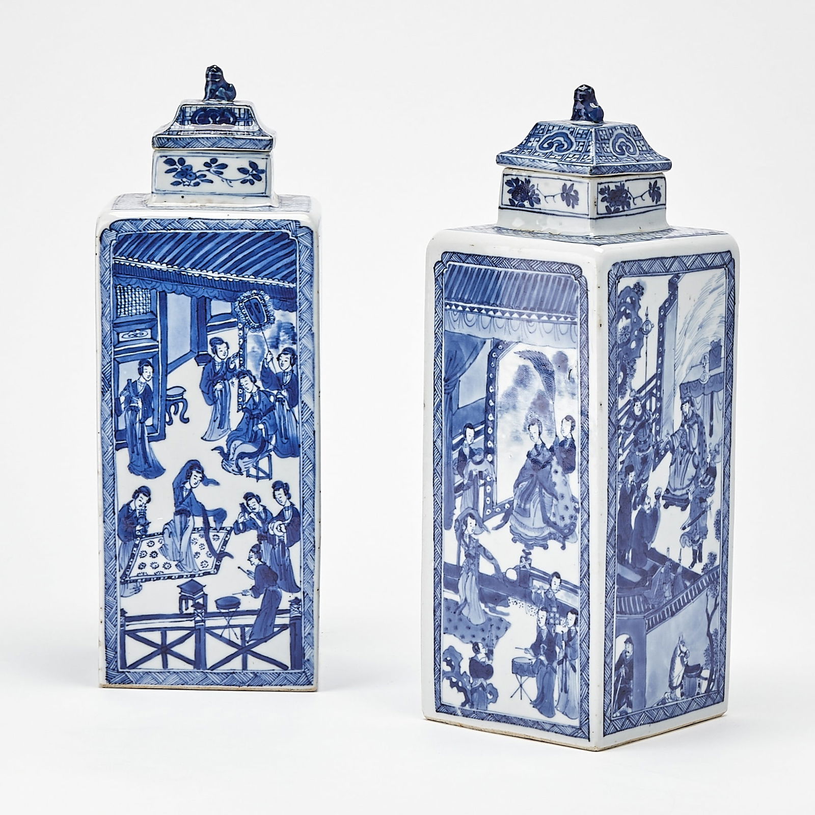 A Pair of Chinese Blue and White Porcelain Square Vases and Covers Kangxi Period: Each of square form, surmounted by a roof-shaped cover with a recumbent lion-form finial; decorated with contiguous scenes from the story of Lady Zhaojun’s Trek to the North within shaped panels