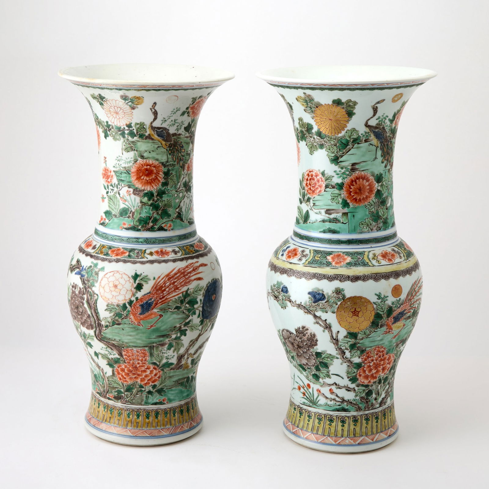 A Pair of Chinese Famille Verte Porcelain Yenyen Vases Kangxi Period: Each decorated to show phoenix perched upon rockwork issuing colorful, flourishing blossoms borne on leafy branches. (Height 18 inches)