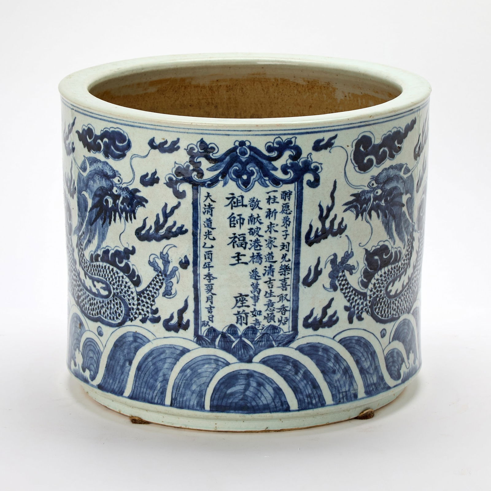 A Chinese Blue and White Porcelain Jardiniere Daoguang Period, Dated 1825: Of slightly tapering cylindrical form; decorated with four-claws, scaly dragons writhing amid flame wisps and cloud scrolls above crashing waves. (Height 12 1/4 inches)