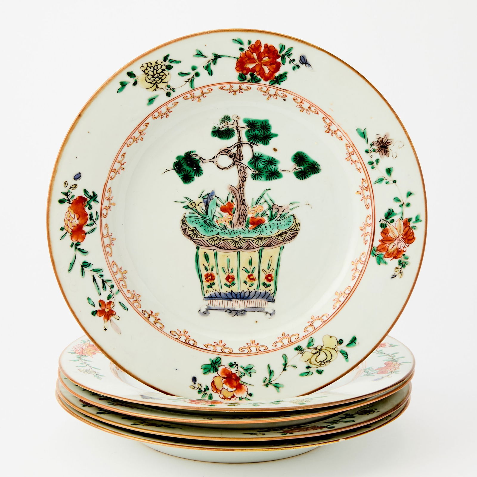 A Group of Five Chinese Famille Verte Porcelain Dishes Kangxi Period: Each of typical form, decorated with a sapling pine tree in a planter, encircled by four flower sprigs. (Diameter 9 inches)