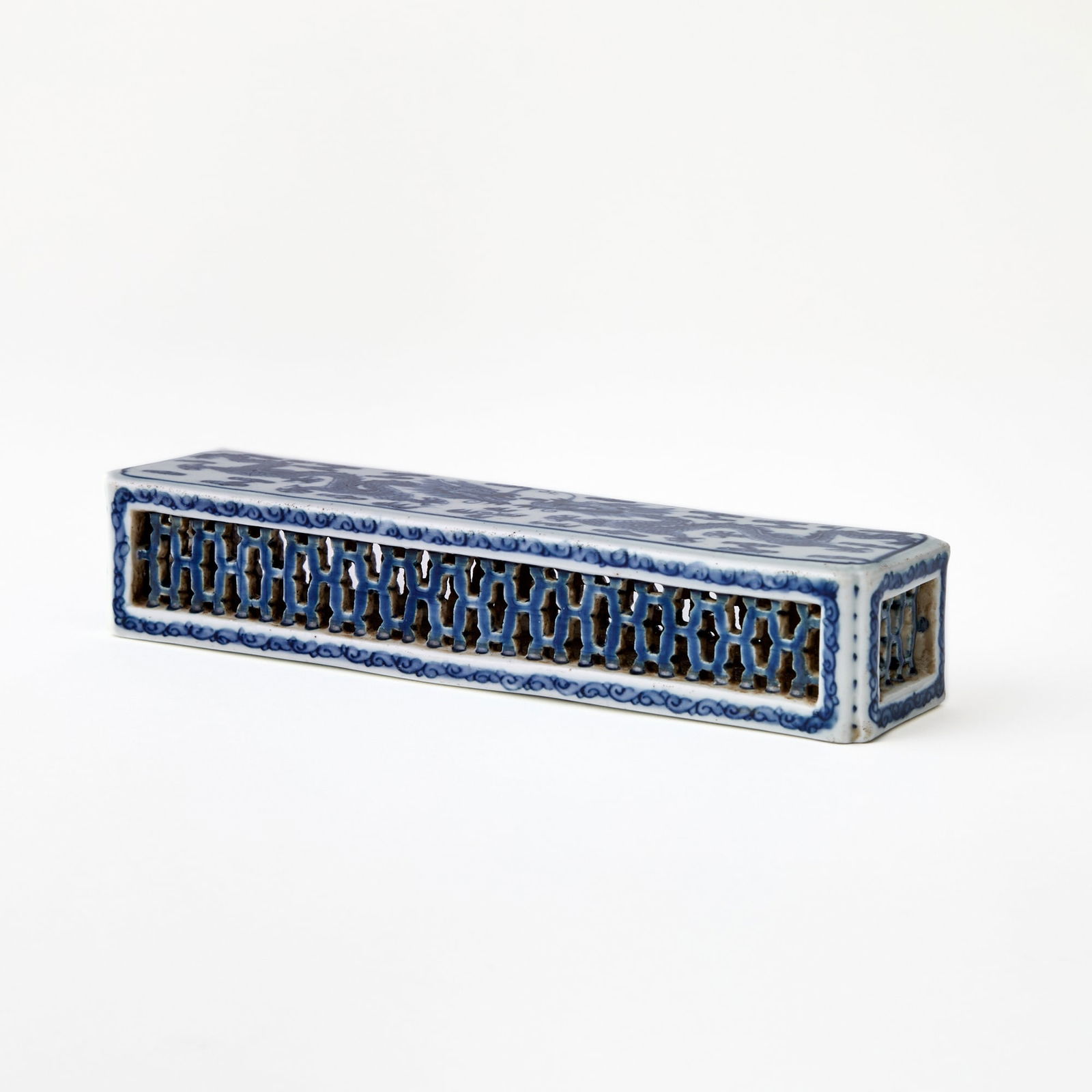 A Chinese Blue and White Porcelain Brush Stand Jiaqing Mark, likely Late Qing Dynasty: The rectangular, vented body decorated with a pair of dragons pursuing a flaming pearl amongst cloud swirls. (Length 7 1/4 inches)