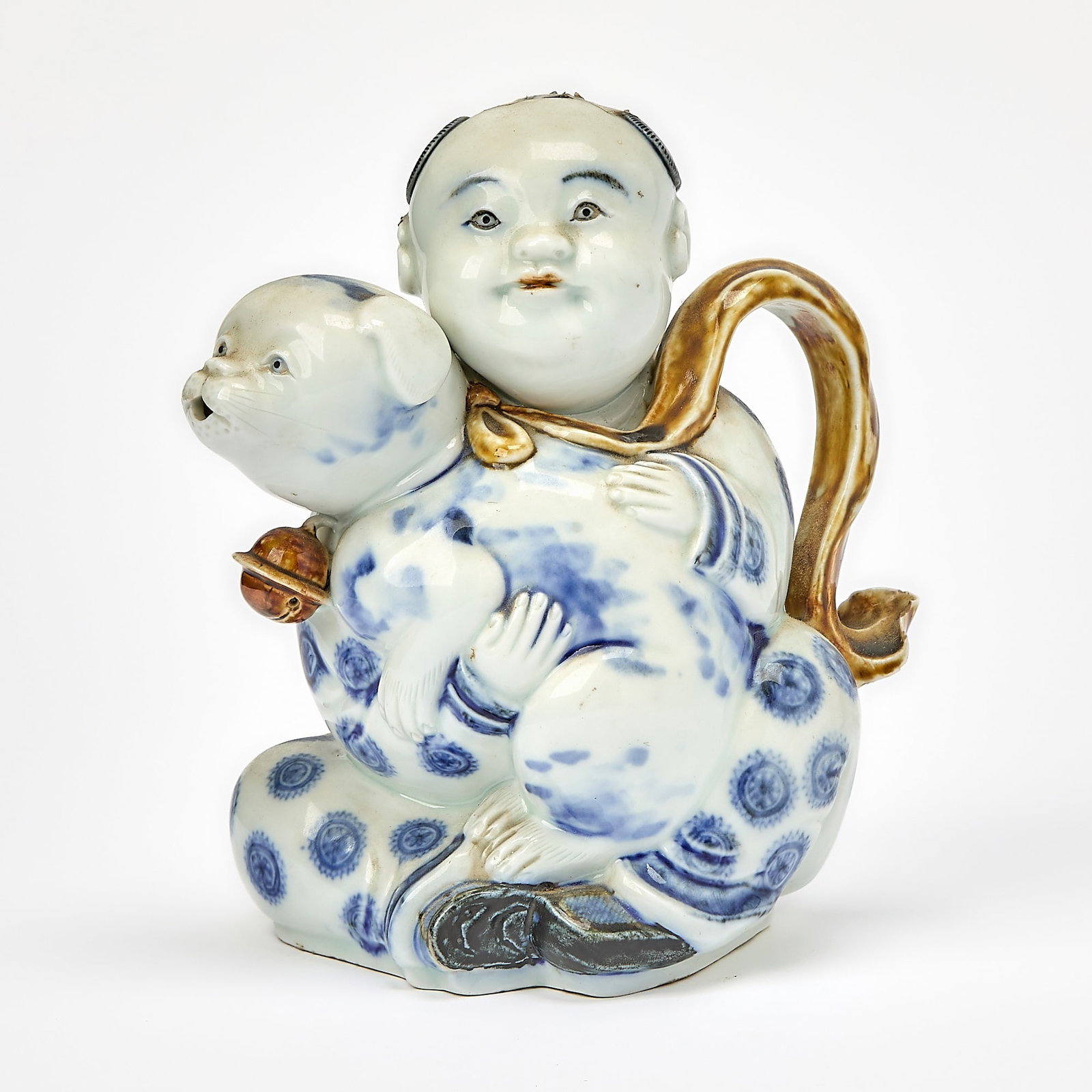 A Japanese Hirado Blue and White and Brown Porcelain Ewer 19th Century: Modeled in the form of a boy holding a dog. (Height 7 3/4 inches)
