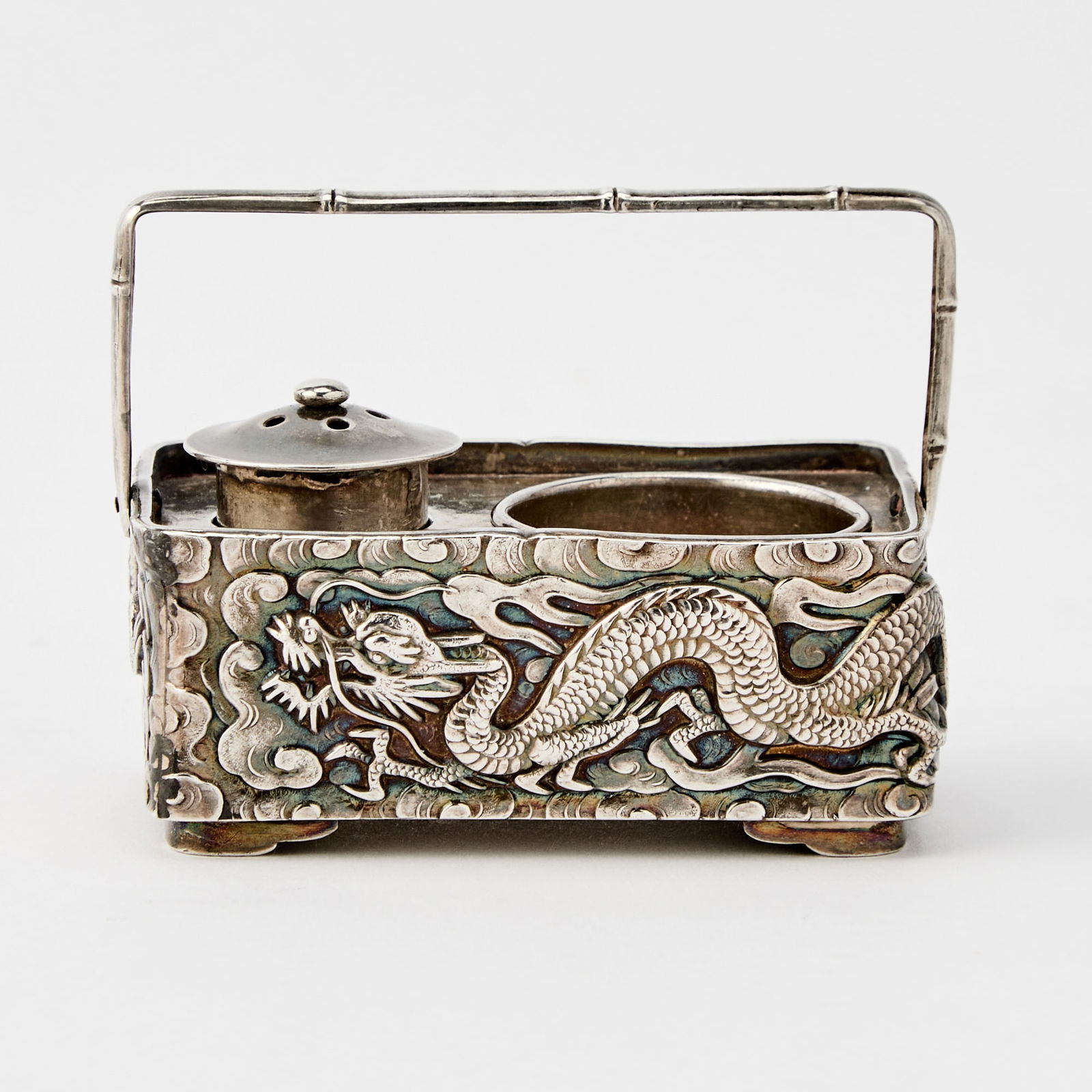 A Japanese Silver Salt and Pepper Set Sealed Jungin, Meiji Period: Of rectangular form with a square-section strap; decorated with a pair of scaly, sinuous dragons amongst scrolling clouds. Weight 1.40 ozt. (Length 2 1/4 inches)