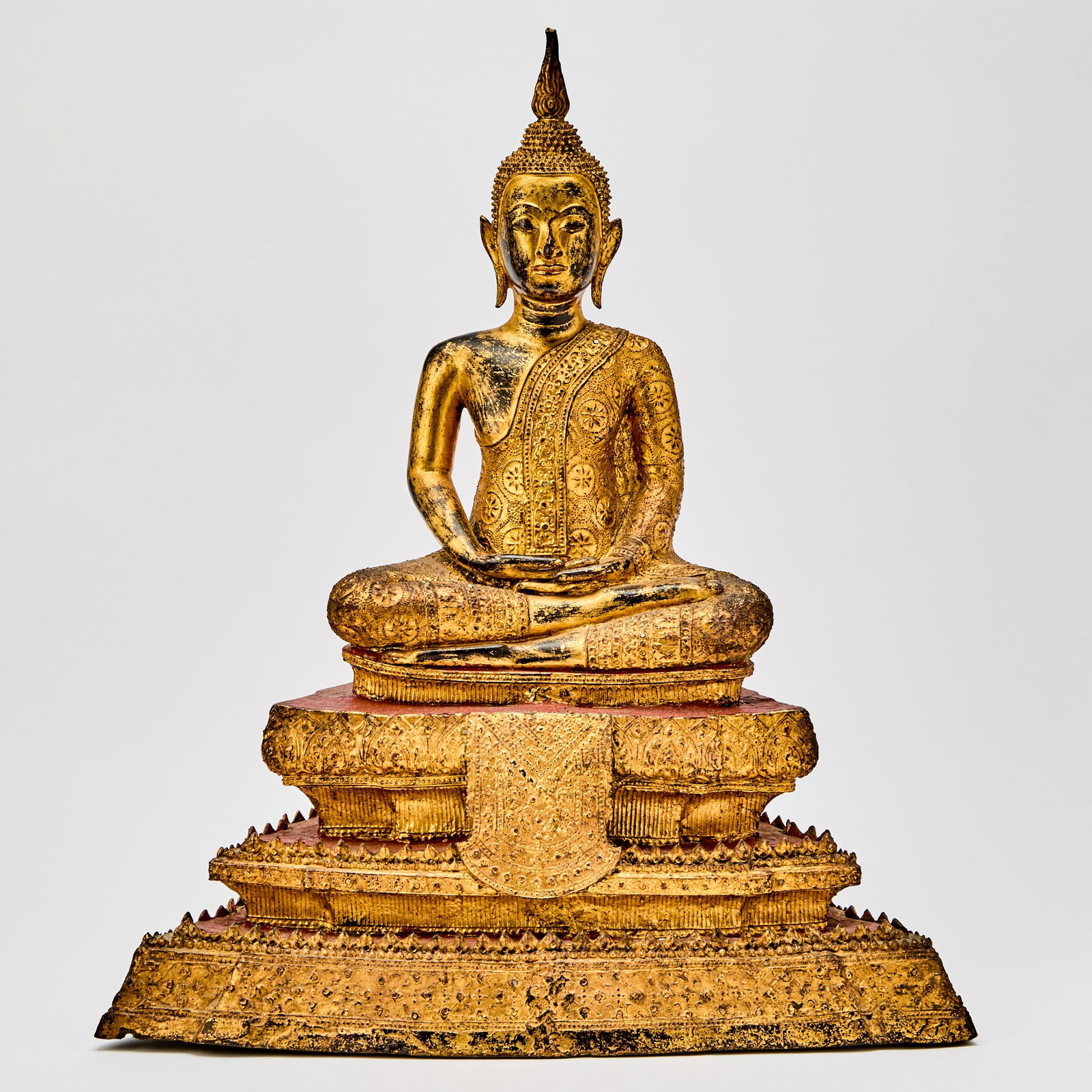 A Thai Gilt Lacquered Bronze Figure of Buddha 18th-19th century: Seated in dhyanasana on a three-tier base, the face with a serene, meditative expression. (Height 20 1/2 inches)