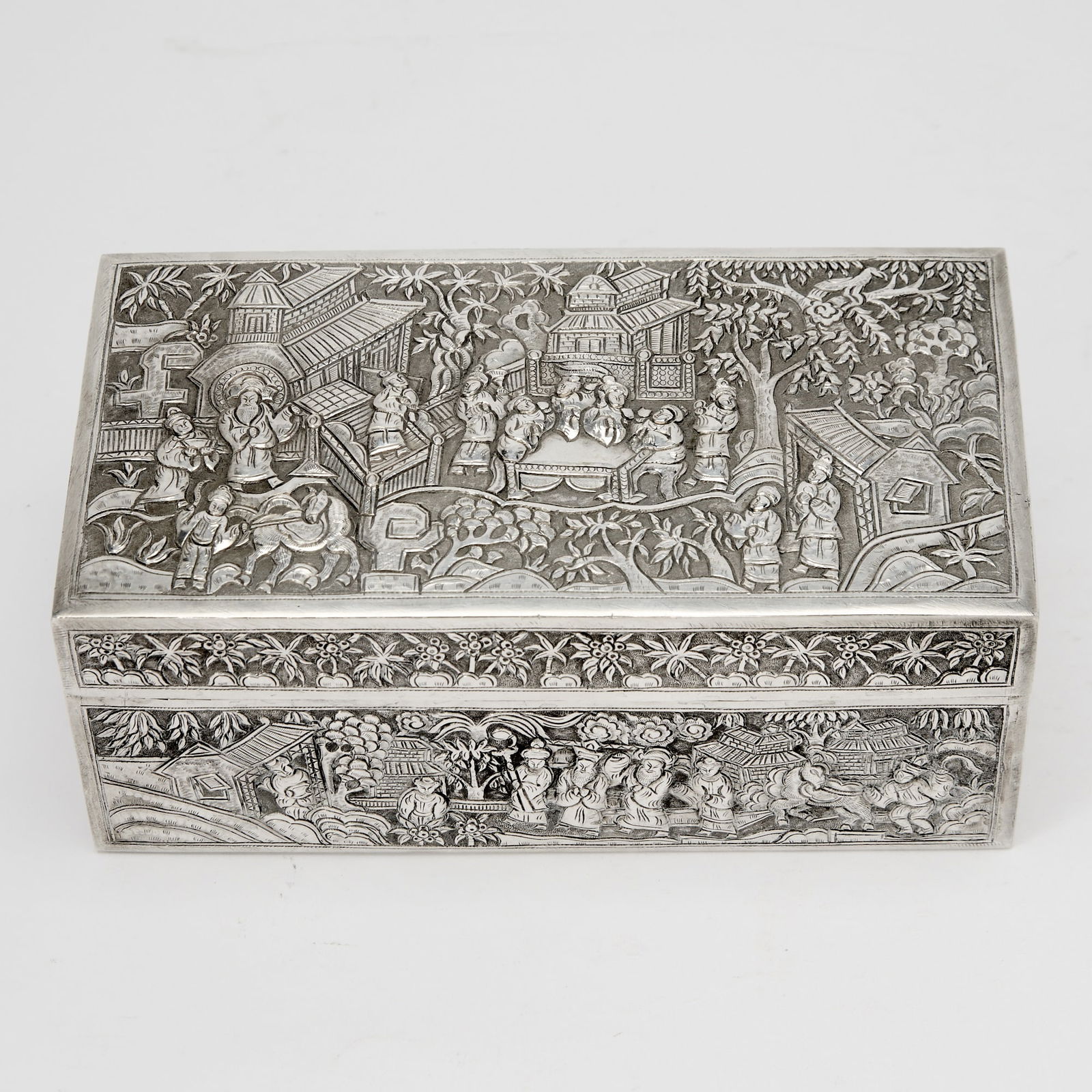 A Chinese Silver Box 19th century: Of rectangular form decorated to show figural scenes in idyllic settings, possibly for the Southeast Asian market. Weight 24.35 ozt. (Width 8 inches)