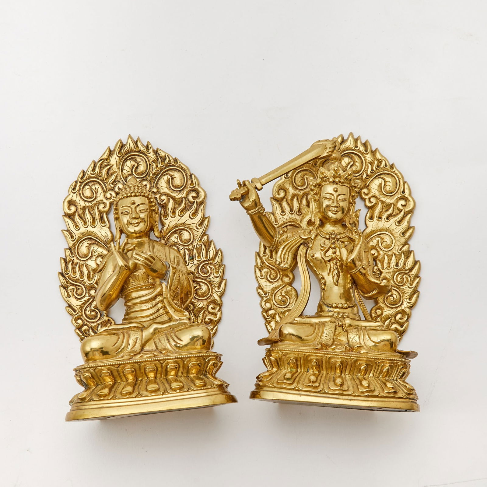 A Pair of Chinese Gilt Bronze Buddhist Figures 19th-20th century or earlier: Depicting Shakyamuni and Majushri, each atop double lotus bases and with arched flaming mandorlas; possibly re-gilt. (Height 7 1/4 inches) Charlotte Horstman & Gerald Godfrey, LTD.; per label