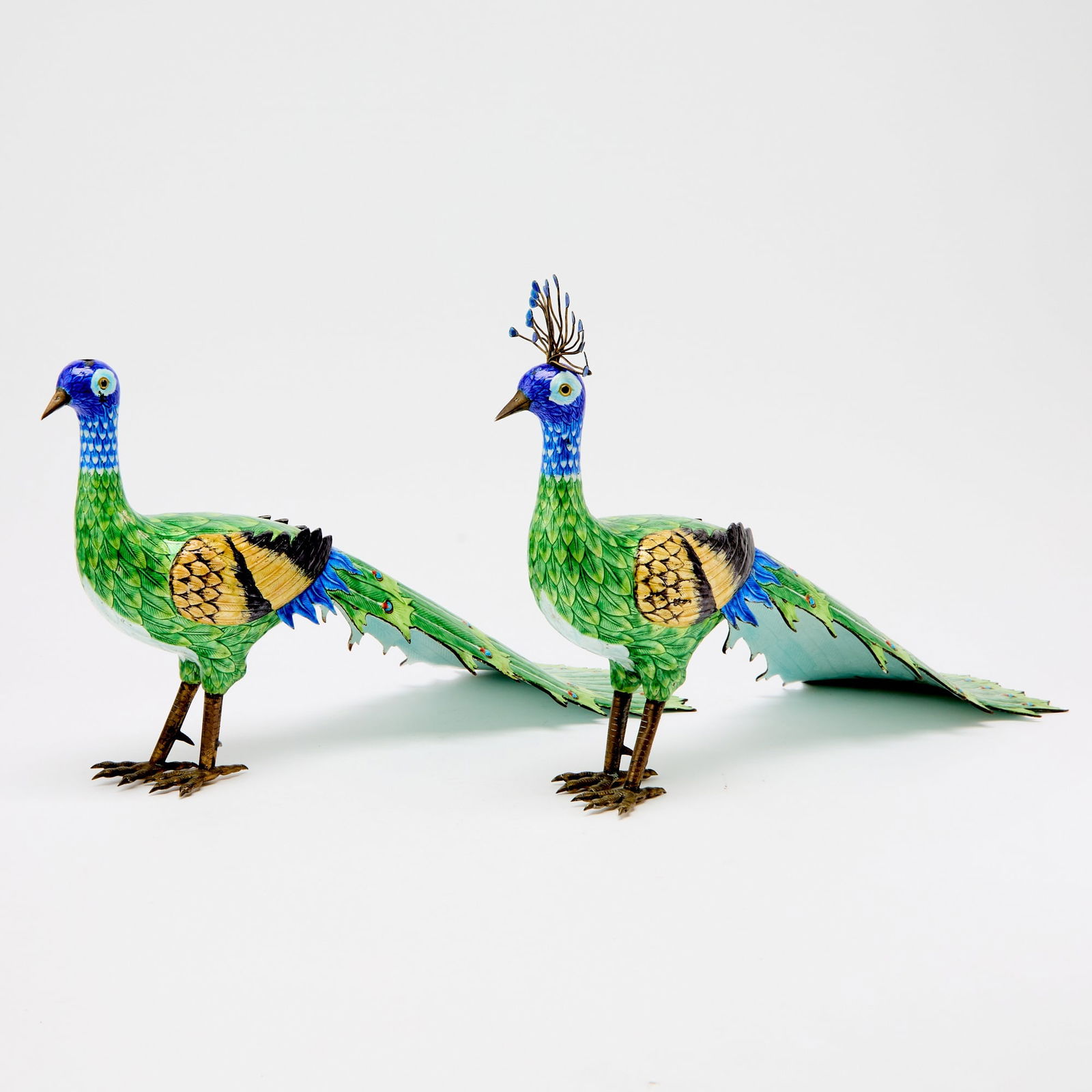A Pair of Chinese Cloisonne Enamel Peacocks Qing Dynasty: Each modeled as a standing bird with a long trailing tail, the bodies brightly enameled. (Length 16 inches)