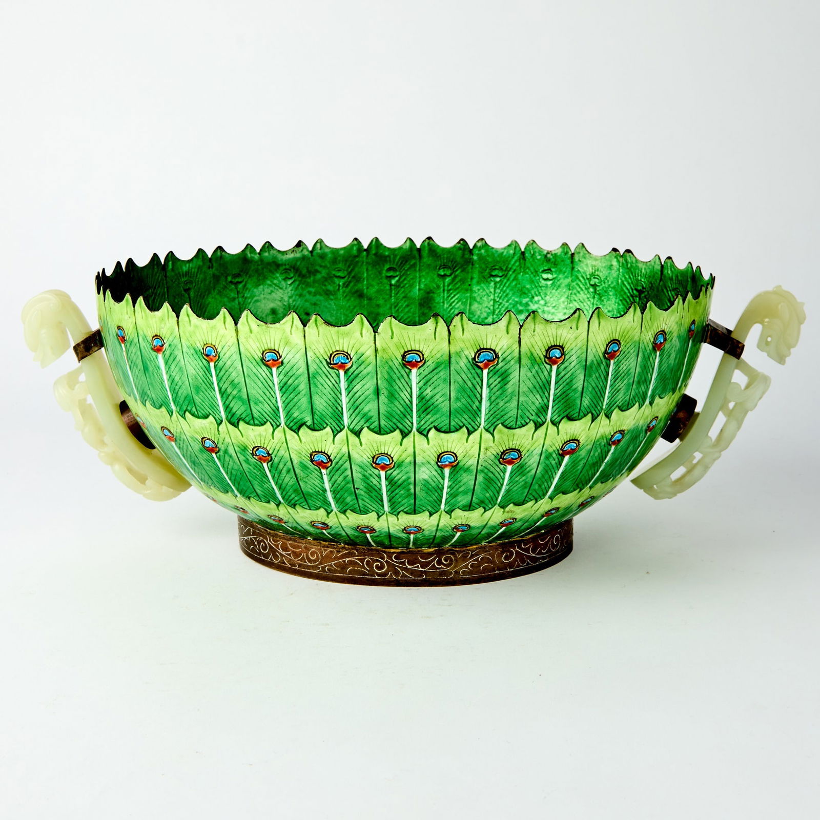 A Large Chinese Cloisonne Enamel Bowl 19th Century: Decorated to the exterior with peacock feather motifs, set with a pair of celadon jade chilong-form belt hooks as handles. (Length 14 inches)