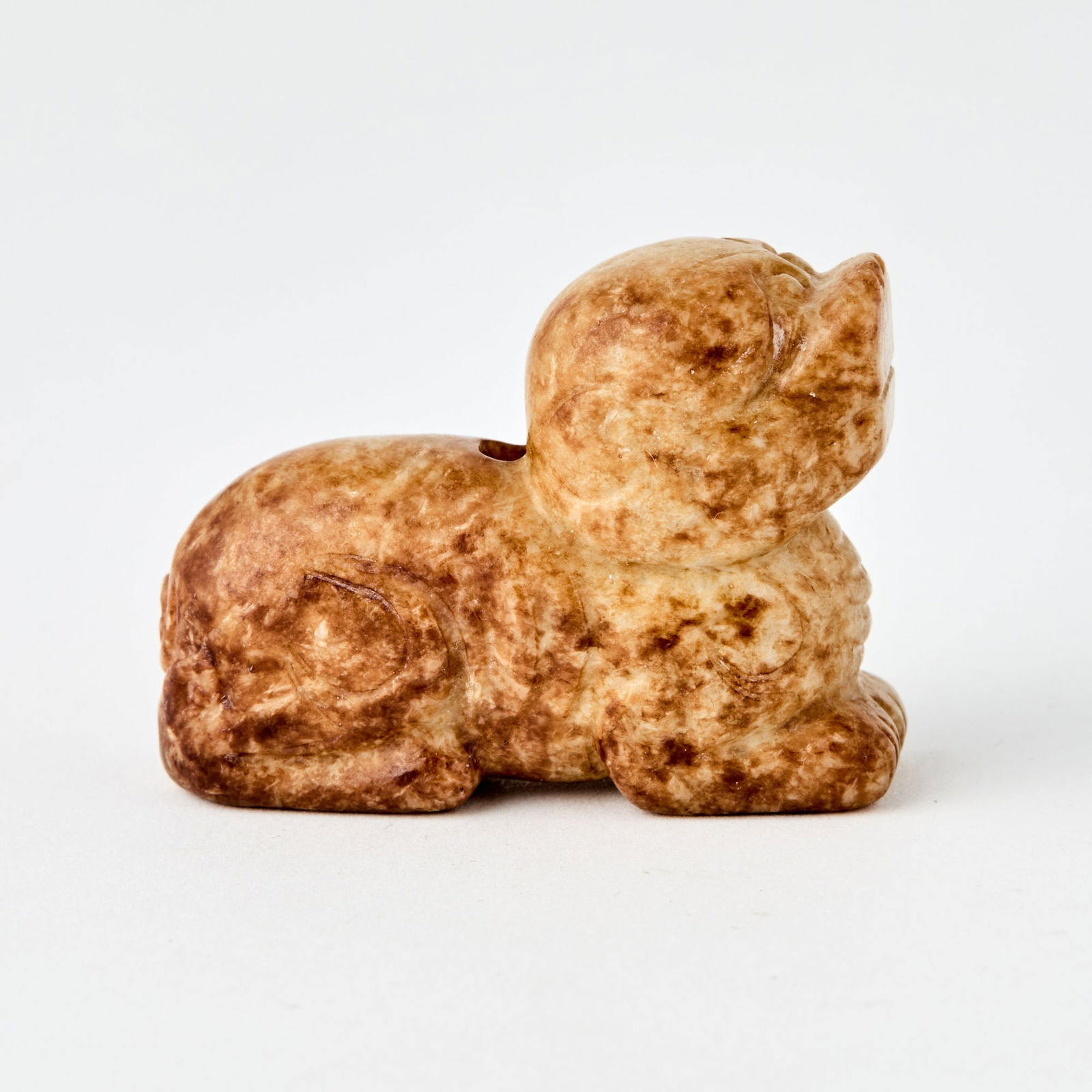 A Chinese Mottled Jade Carving of a Qilin: Carved as a recumbent qilin with its head raised. (Length 1 3/4 inches)