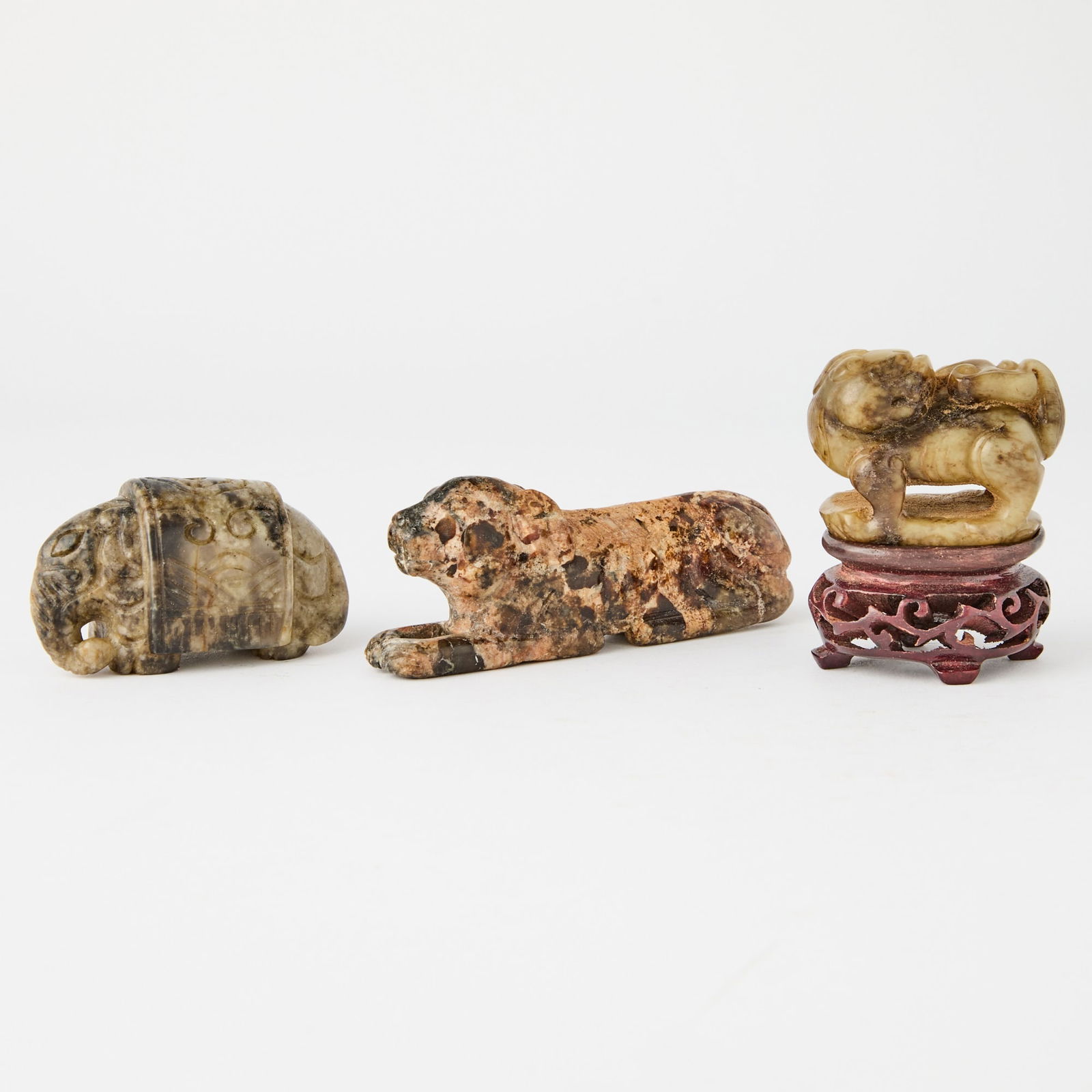 Three Chinese Ming-Style Jade Carvings: Comprising a recumbent elephant, a hound, and a qilin with its head turned backwards. (Length 3 1/2 inches)